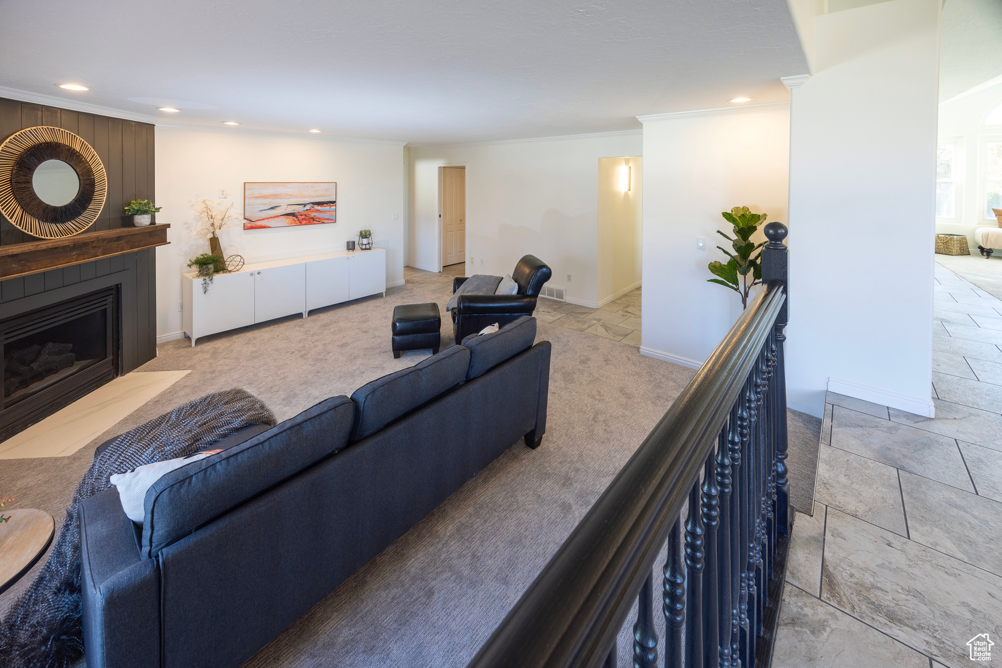 Living room with ornamental molding, recessed lighting, a large fireplace, and baseboards