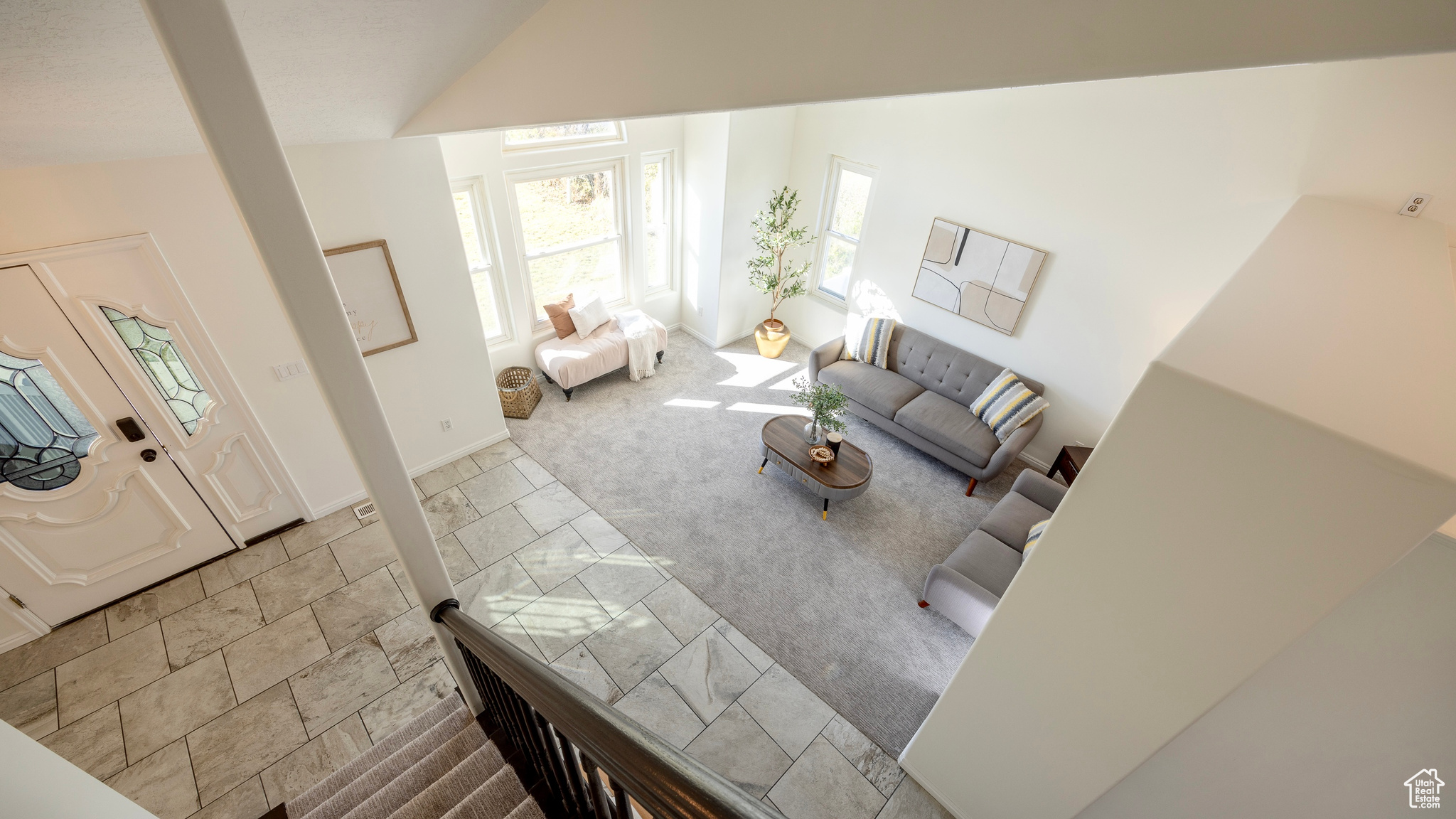 Living area with carpet floors, lofted ceiling, stone finish flooring, and baseboards