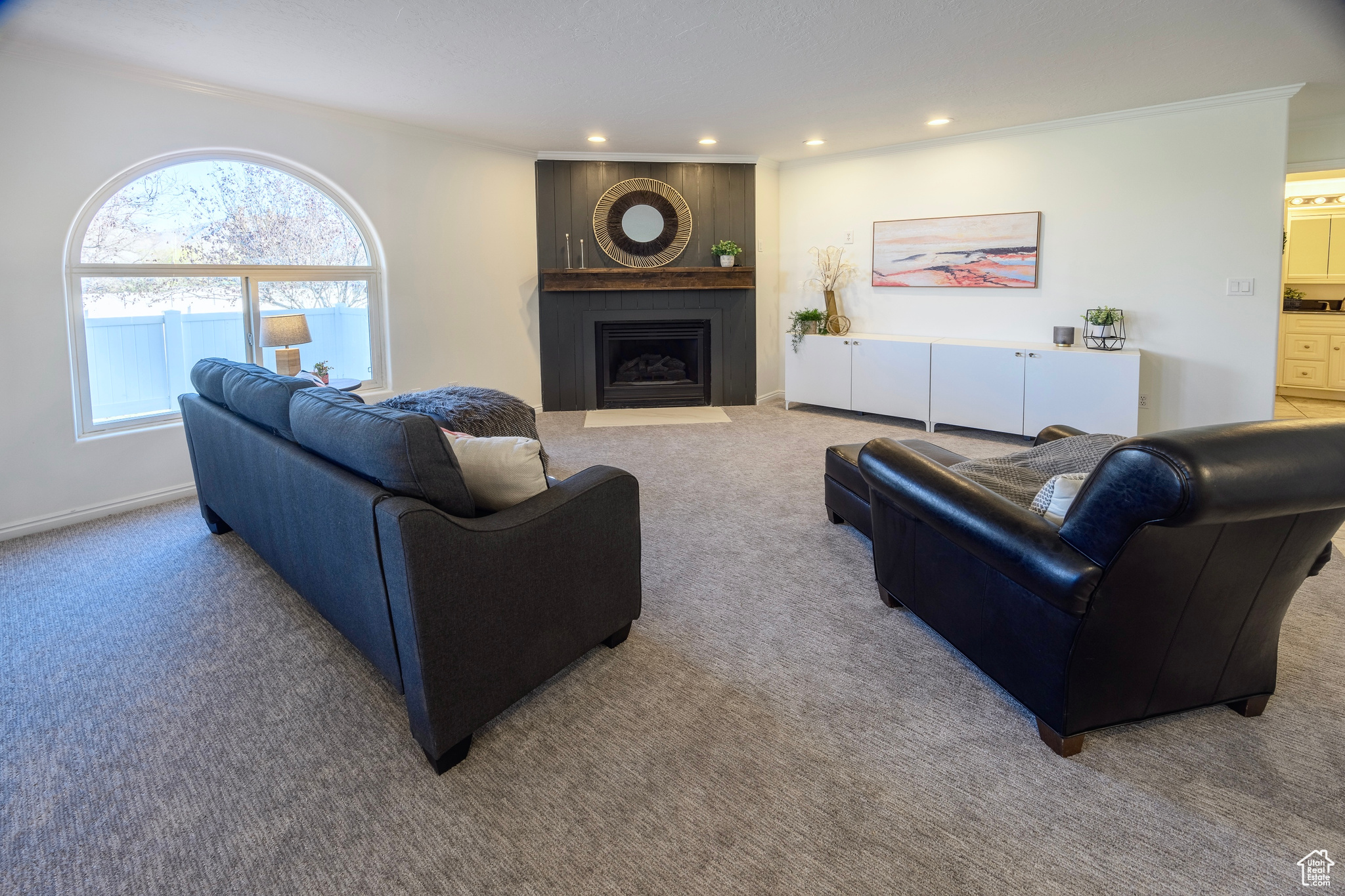 Carpeted living area featuring recessed lighting, a large fireplace, and crown molding