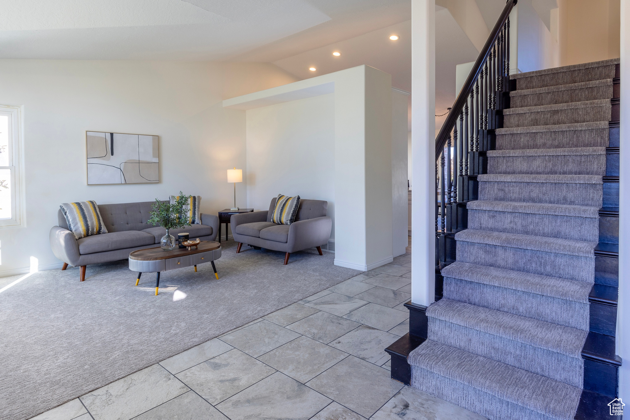 Living area featuring vaulted ceiling, recessed lighting, stairs, and light colored carpet