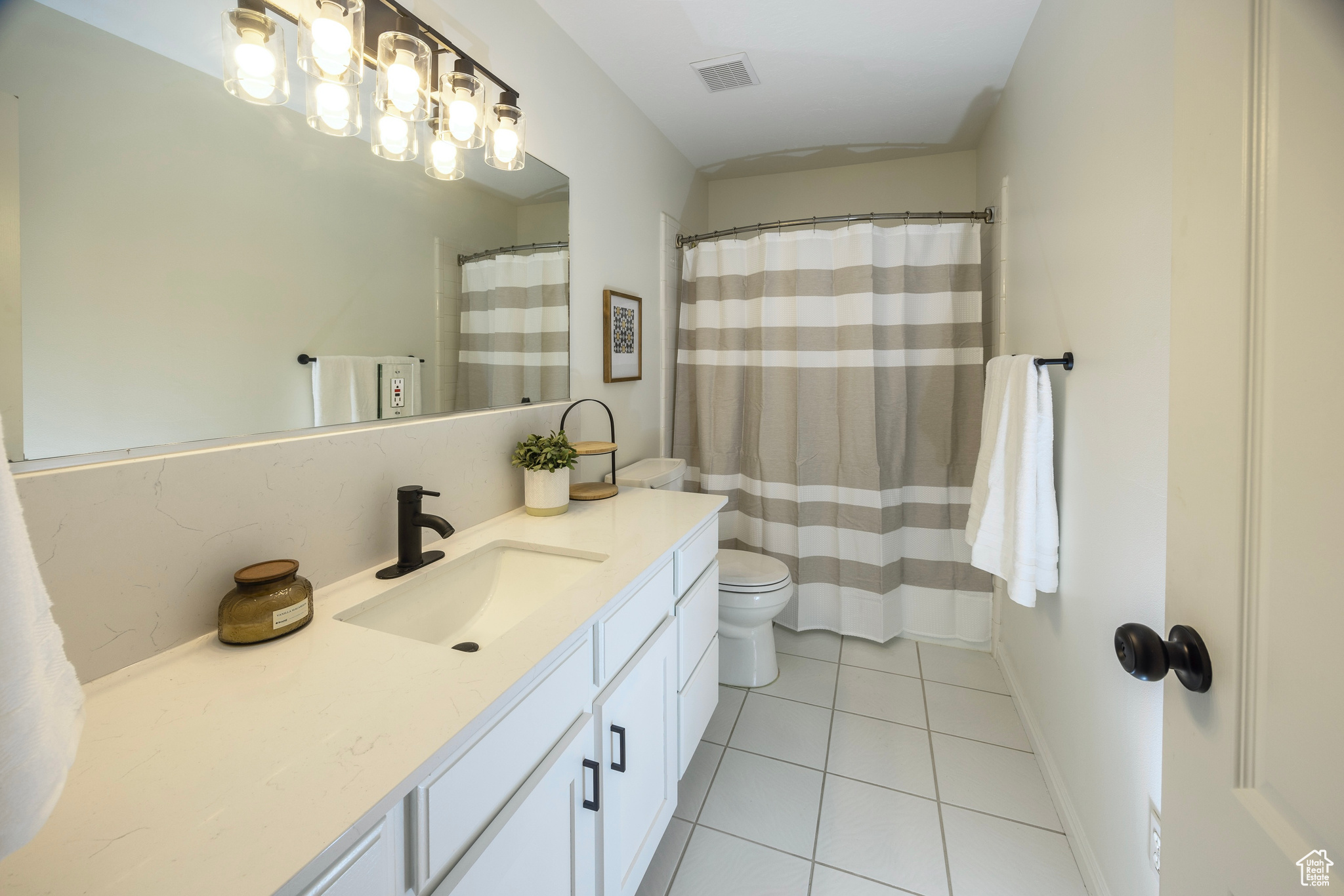 Full bathroom with visible vents, toilet, vanity, tile patterned flooring, and baseboards