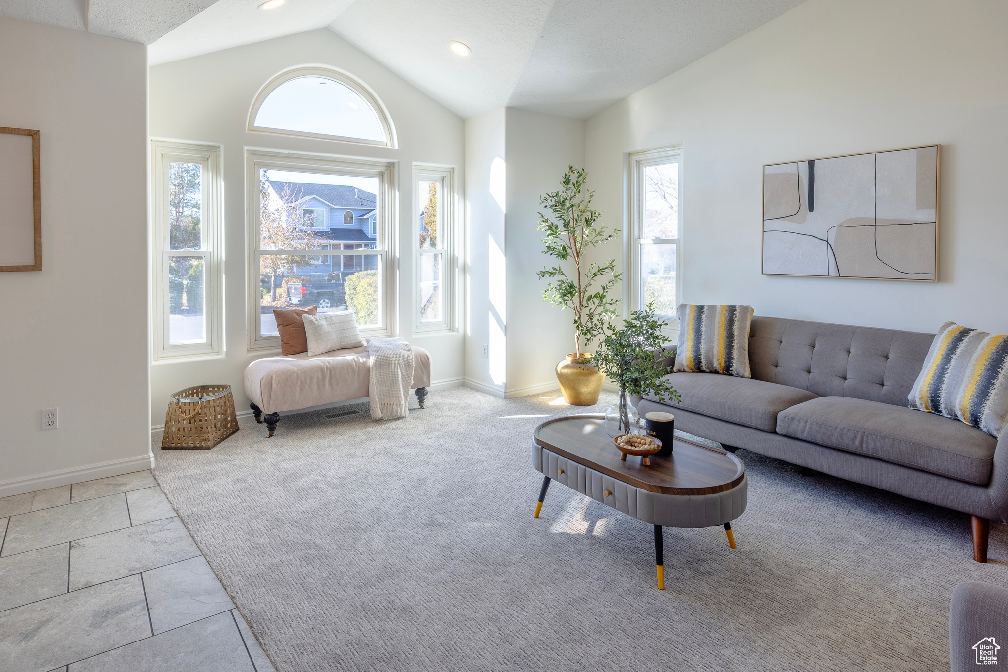 Carpeted living room with baseboards, vaulted ceiling, and recessed lighting