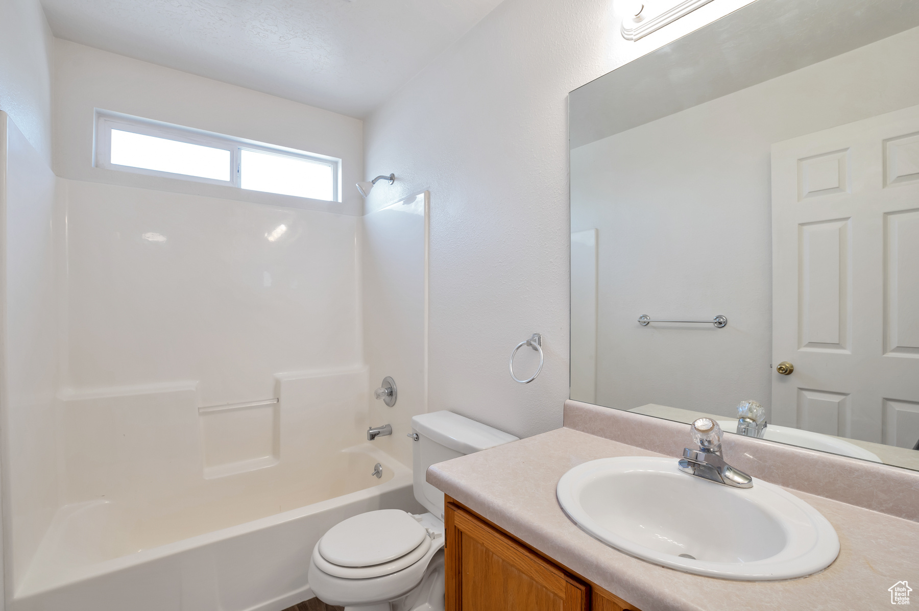 Bathroom featuring toilet,  shower combination, and vanity