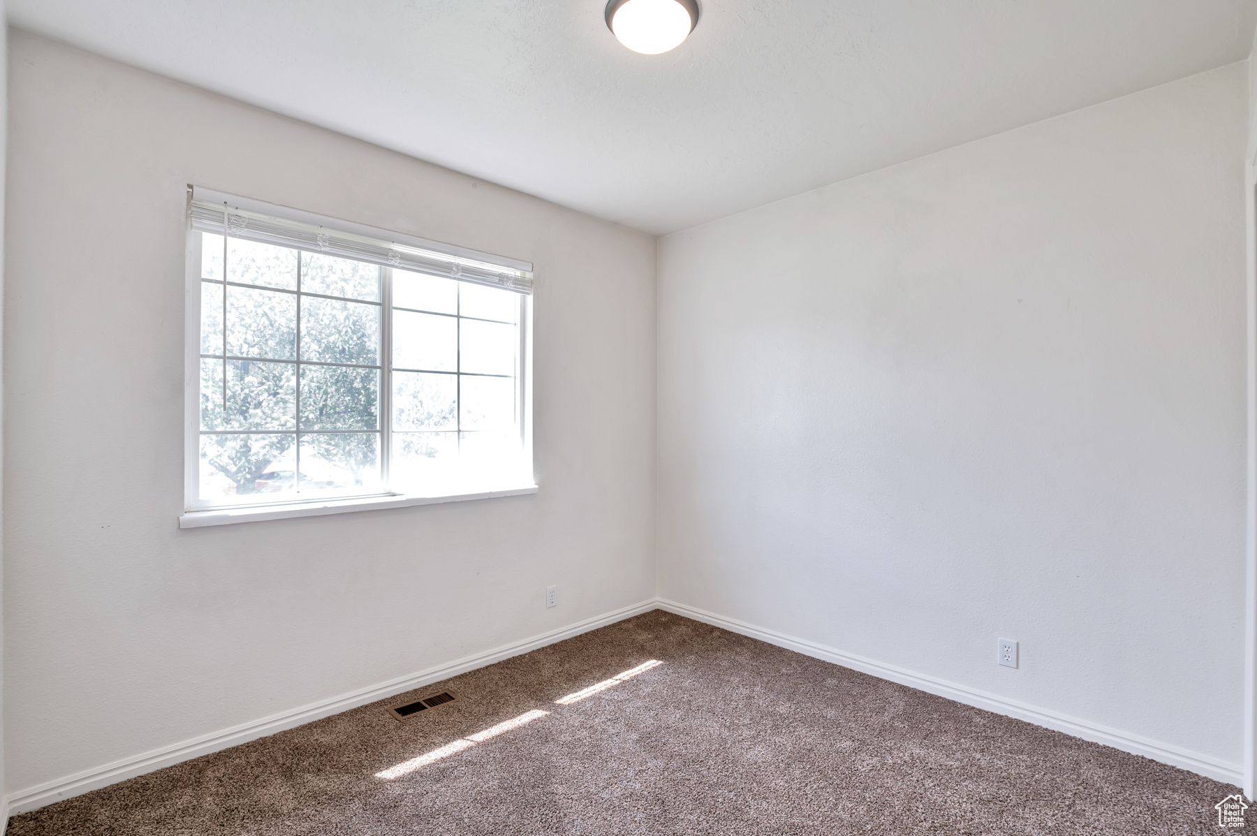 Spare room with carpet flooring, baseboards, and visible vents