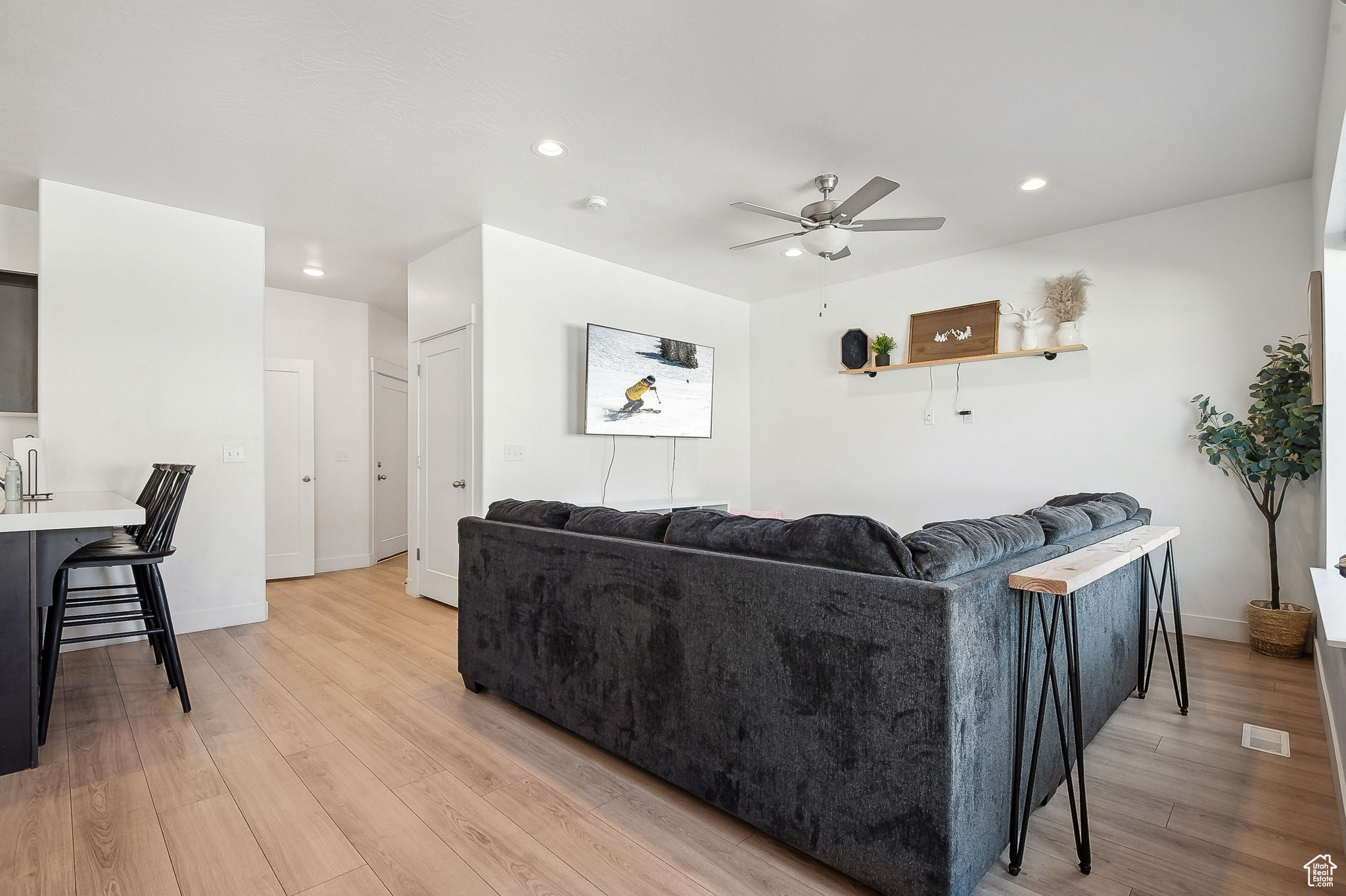 Living room with ceiling fan, recessed lighting, light wood-style flooring, and baseboards