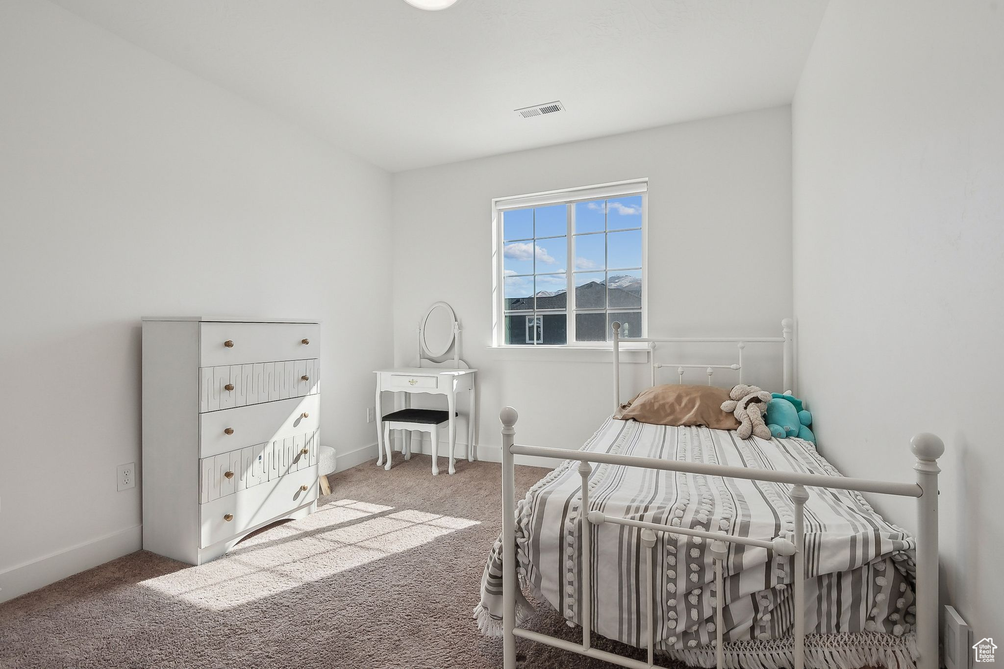 Carpeted bedroom featuring visible vents and baseboards