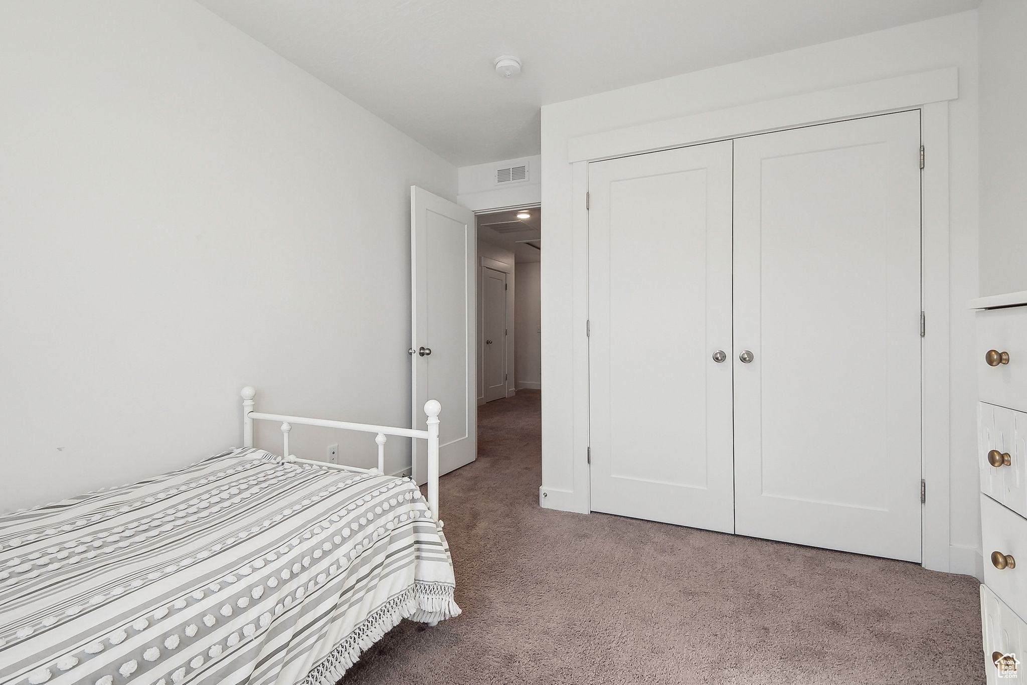 Bedroom featuring carpet floors, visible vents, and a closet
