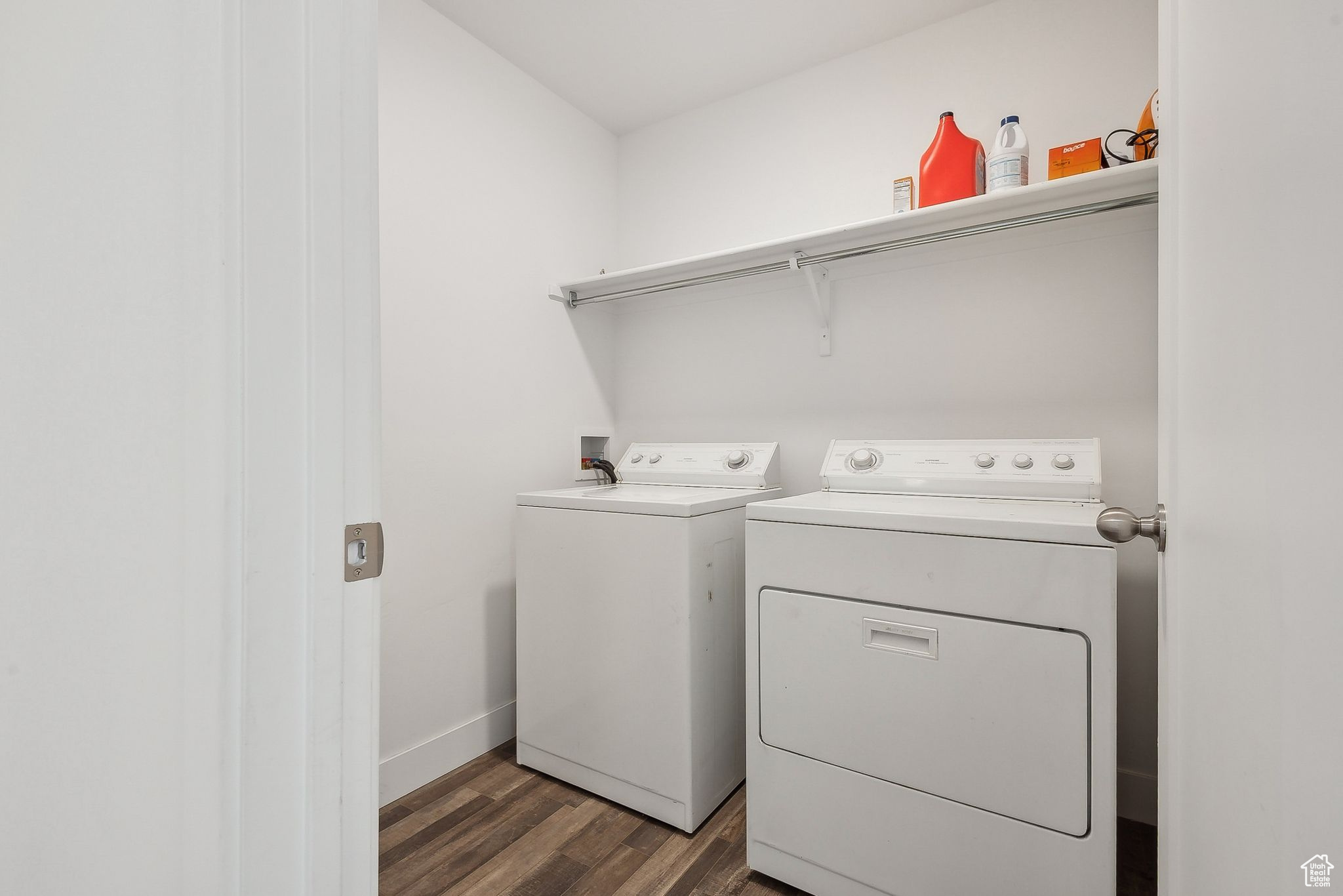 Laundry room featuring laundry area, washer and clothes dryer, wood finished floors, and baseboards