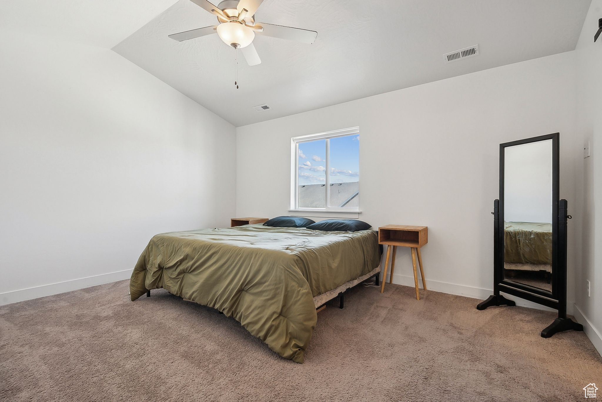Bedroom featuring lofted ceiling, light colored carpet, a ceiling fan, baseboards, and visible vents