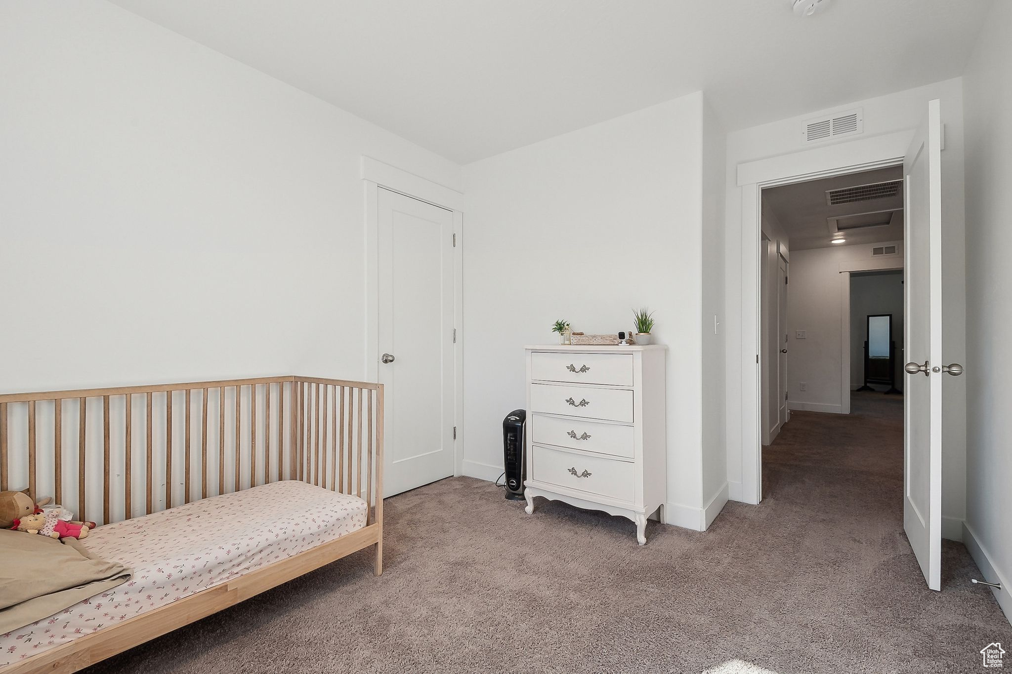 Bedroom featuring light carpet, baseboards, and visible vents
