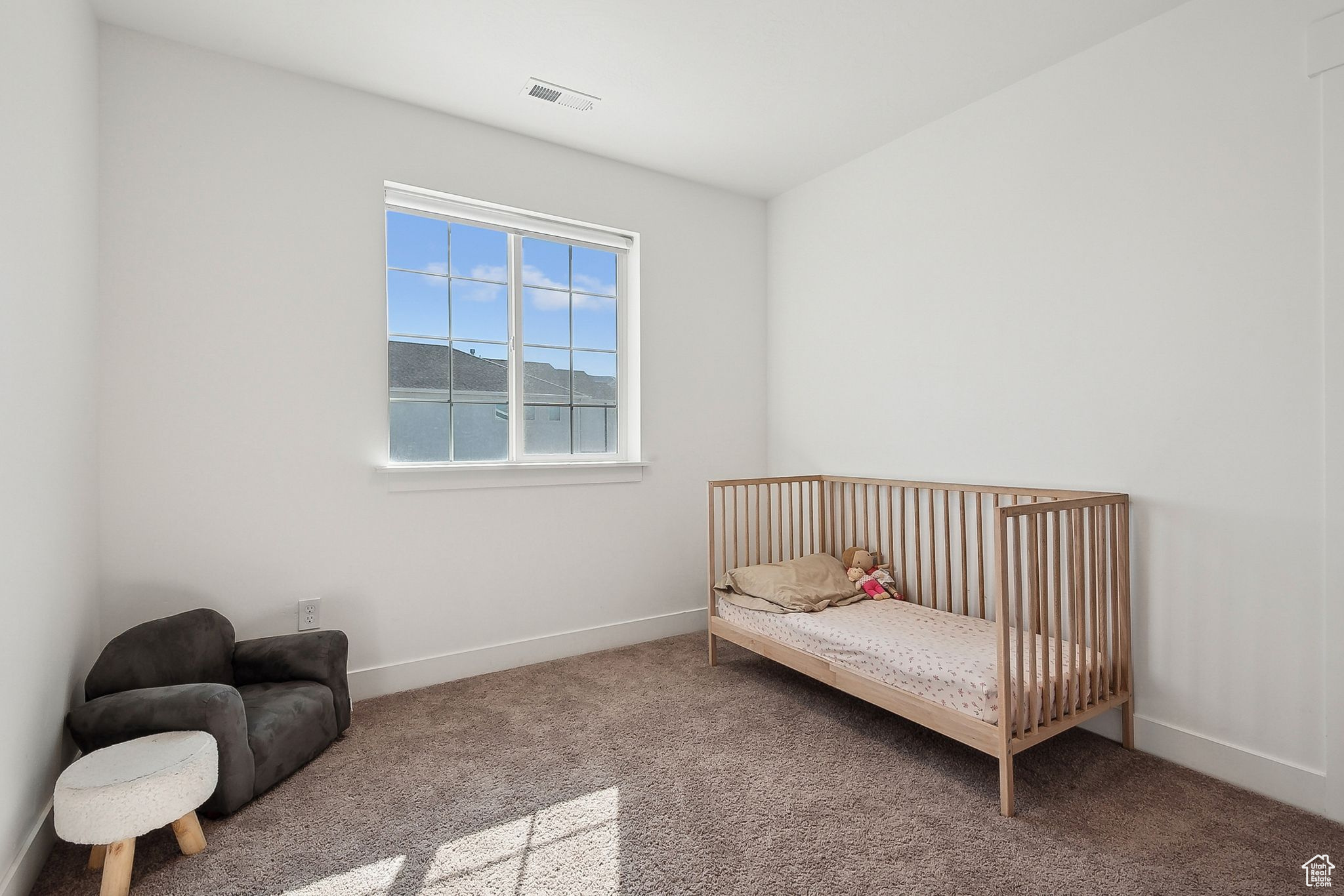Carpeted bedroom with visible vents and baseboards