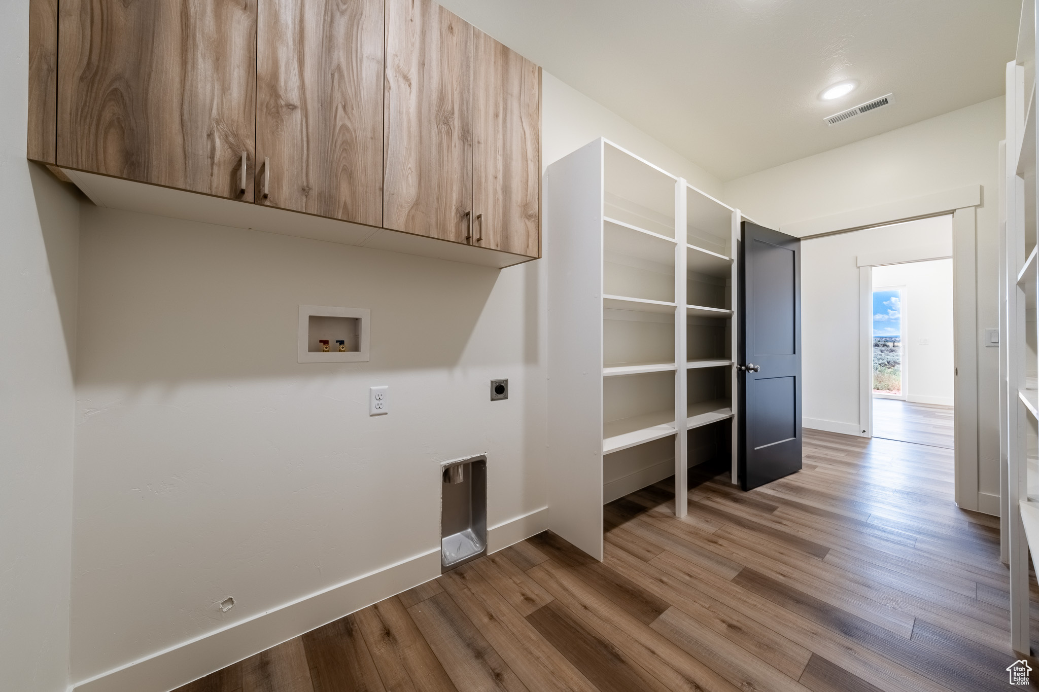 Clothes washing area with visible vents, wood finished floors, cabinet space, hookup for an electric dryer, and hookup for a washing machine