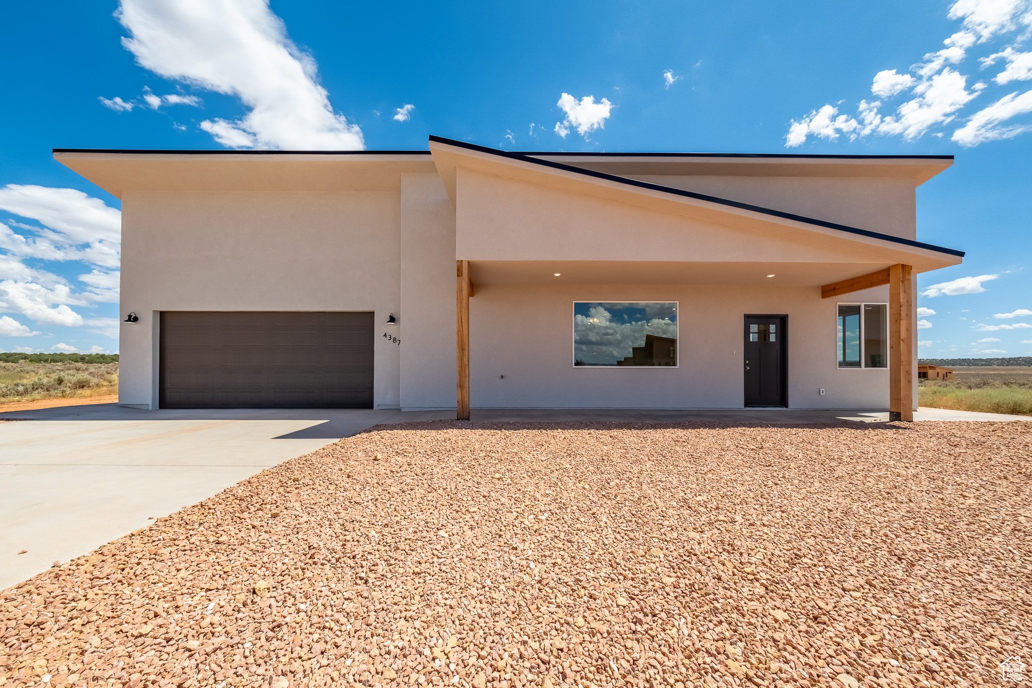 View of front of property featuring concrete driveway, a garage, and stucco siding
