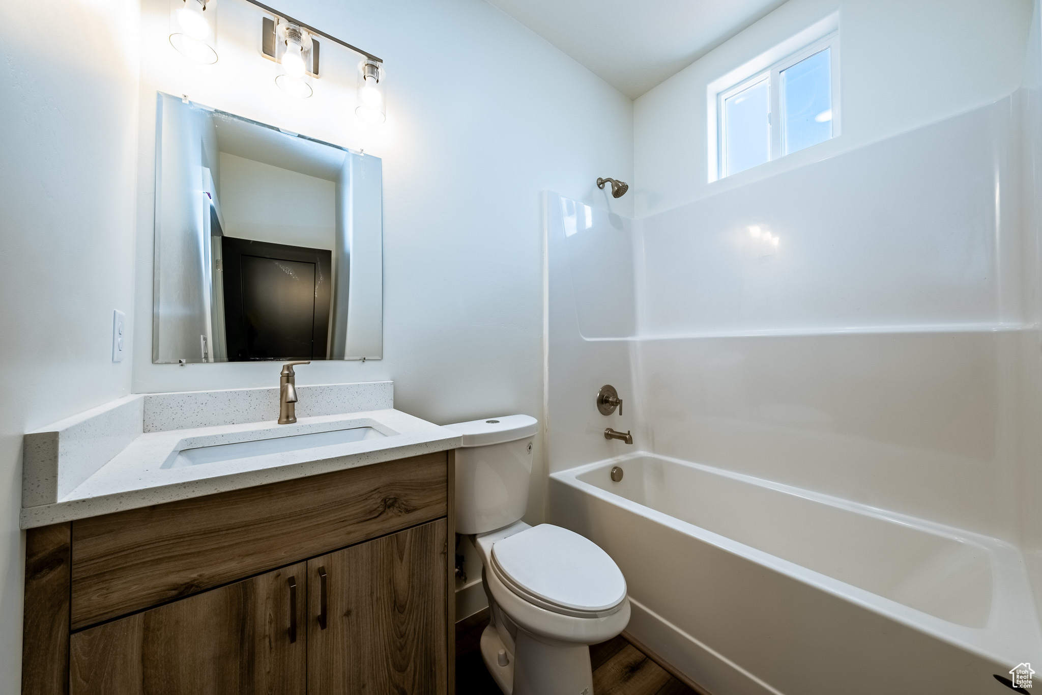 Bathroom featuring bathing tub / shower combination, toilet, and vanity