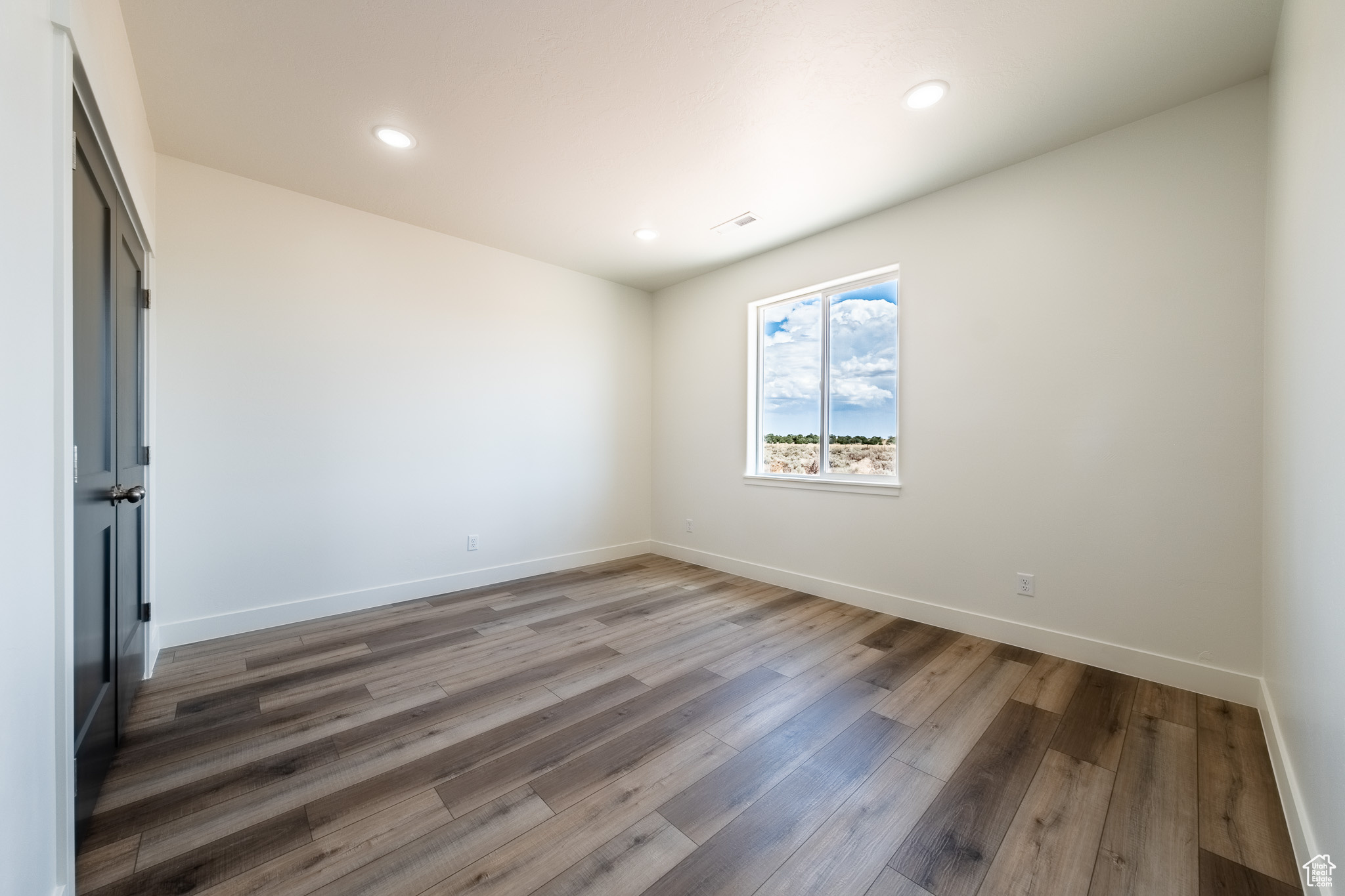 Unfurnished room featuring recessed lighting, wood finished floors, and baseboards