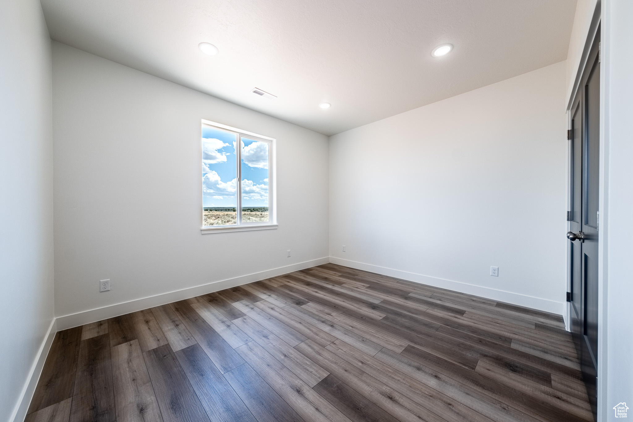 Unfurnished bedroom featuring recessed lighting, baseboards, and dark wood-style floors