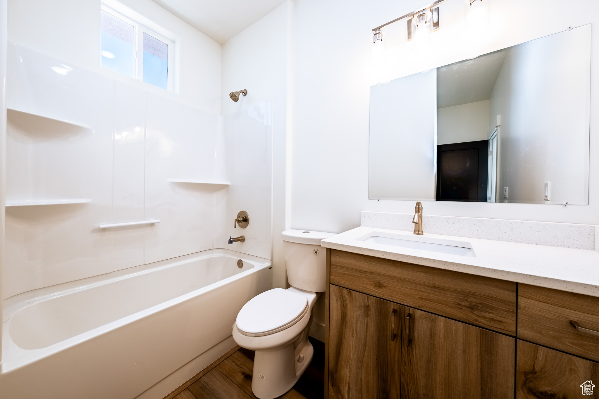 Bathroom with vanity, toilet, wood finished floors, and bathing tub / shower combination