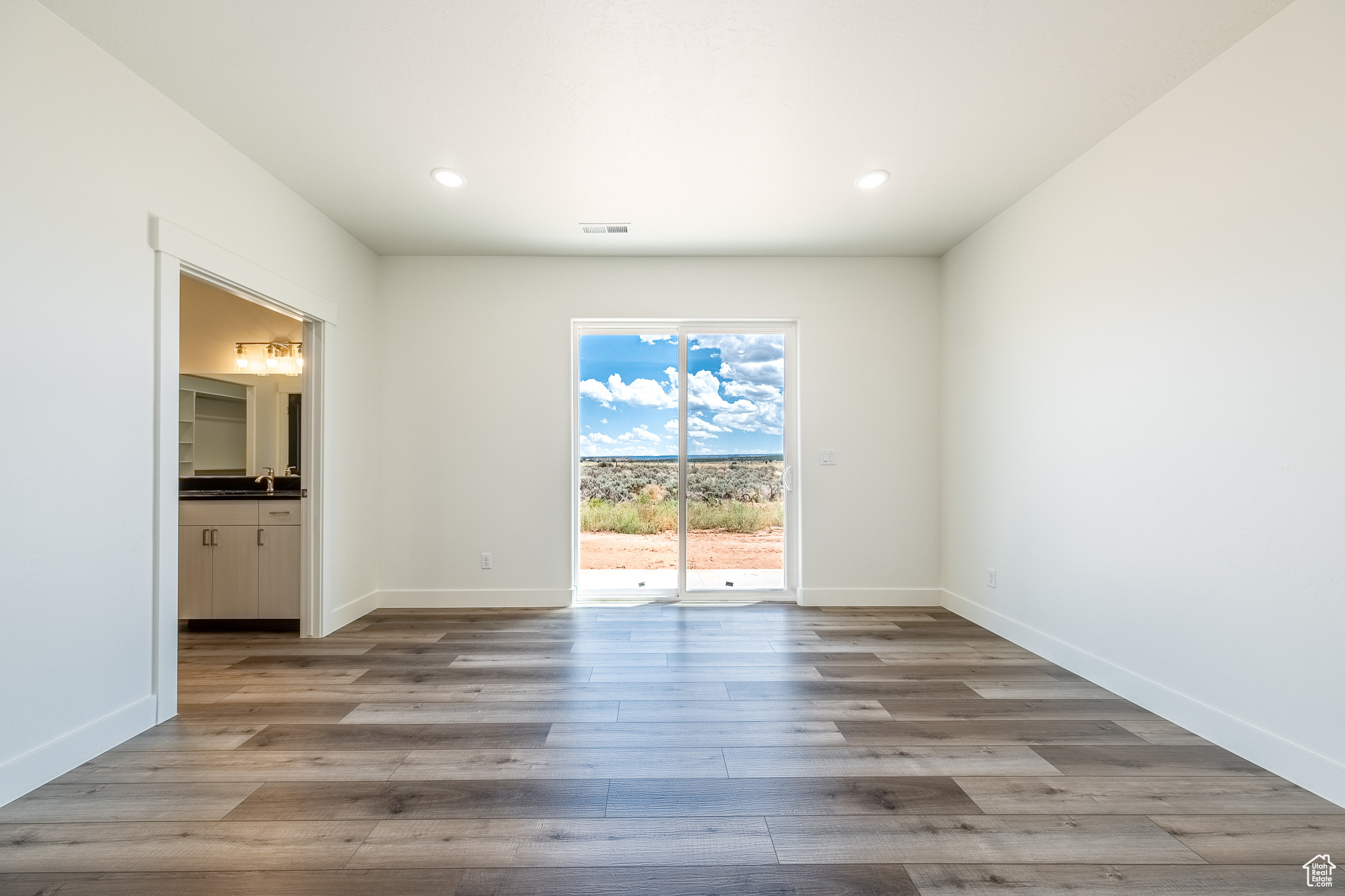Unfurnished room with visible vents, recessed lighting, wood finished floors, and baseboards