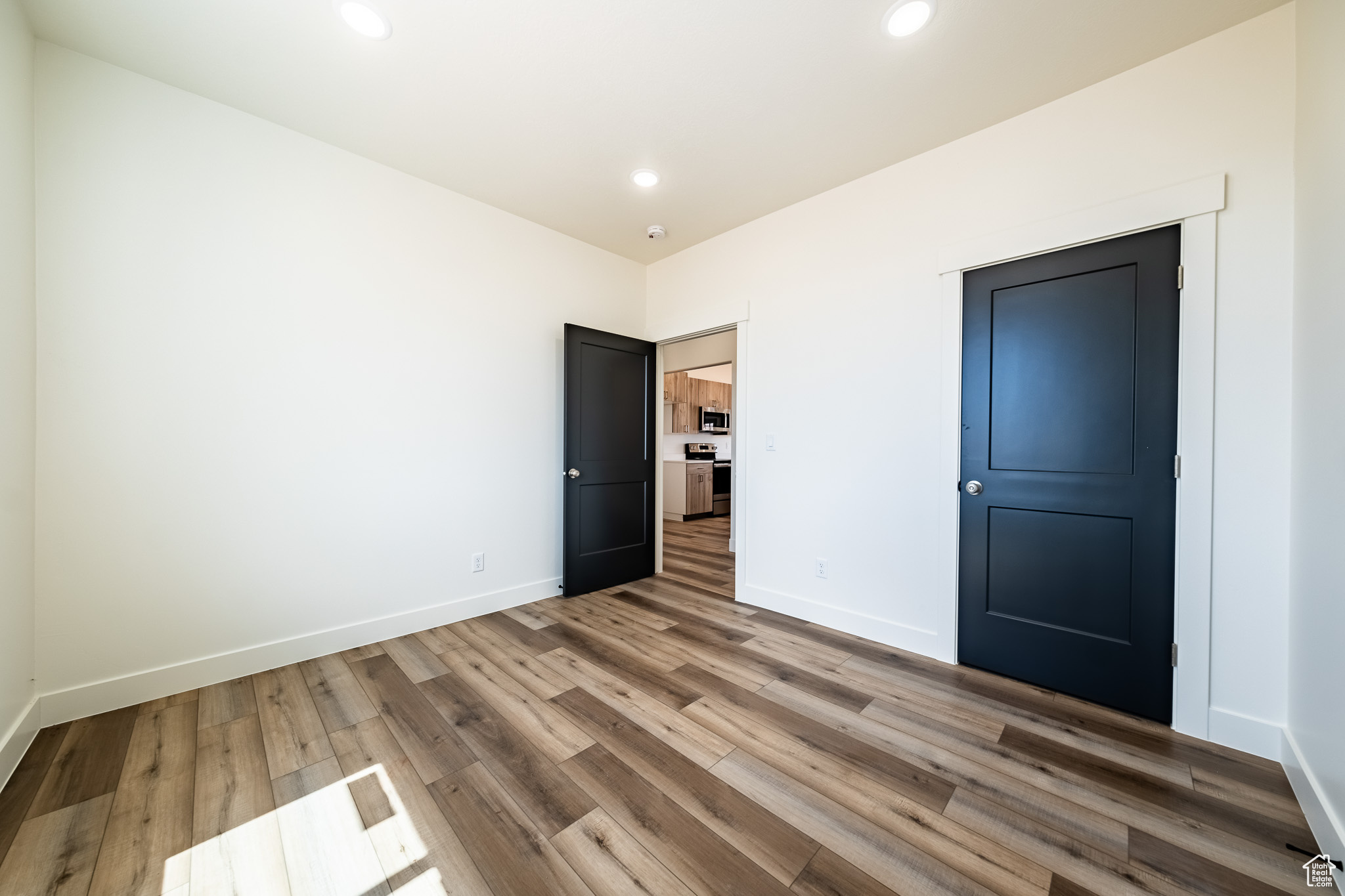 Unfurnished bedroom with recessed lighting, wood finished floors, and baseboards