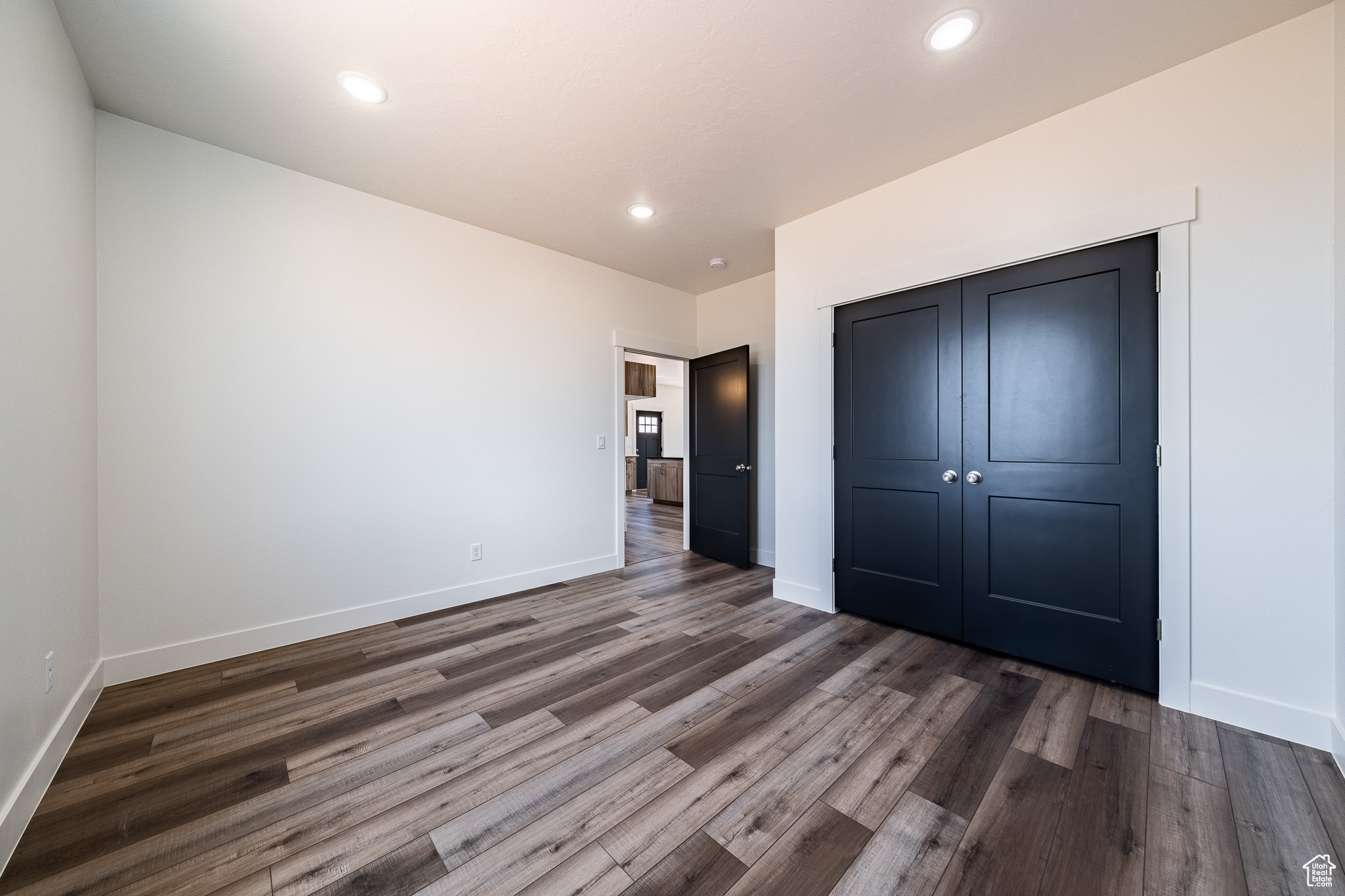 Unfurnished bedroom featuring recessed lighting, baseboards, and dark wood-style floors