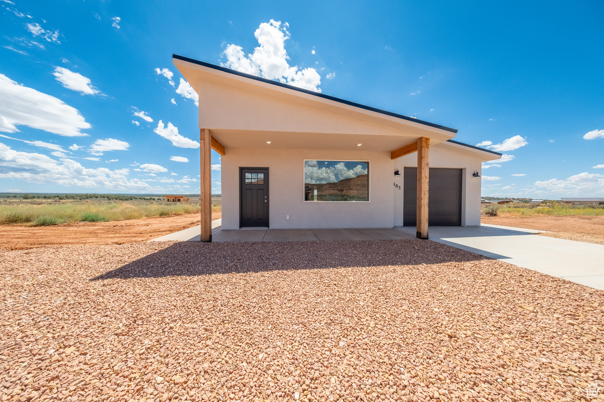 View of front of home with stucco siding, driveway, and a garage