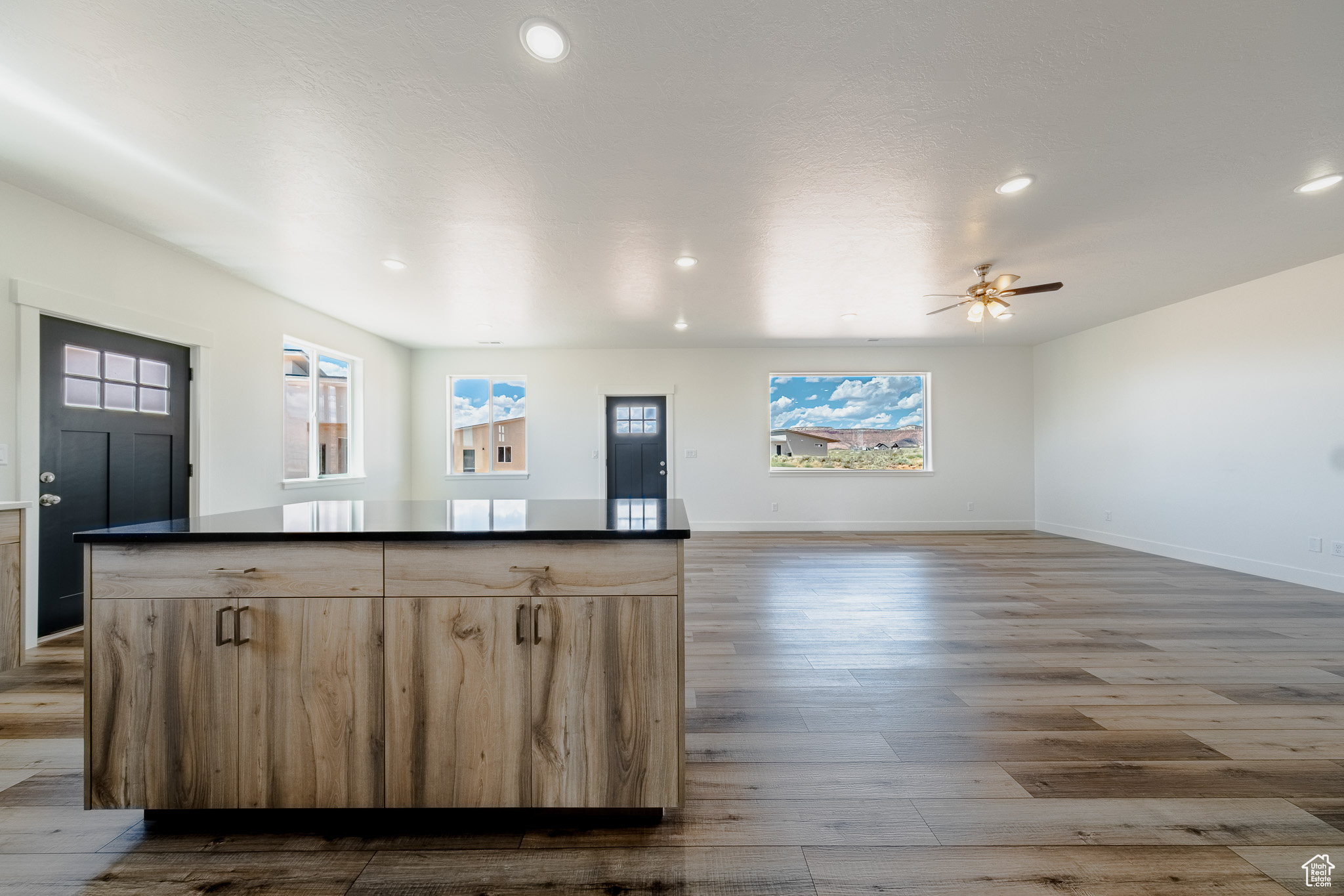 Kitchen with dark countertops, a kitchen island, and wood finished floors