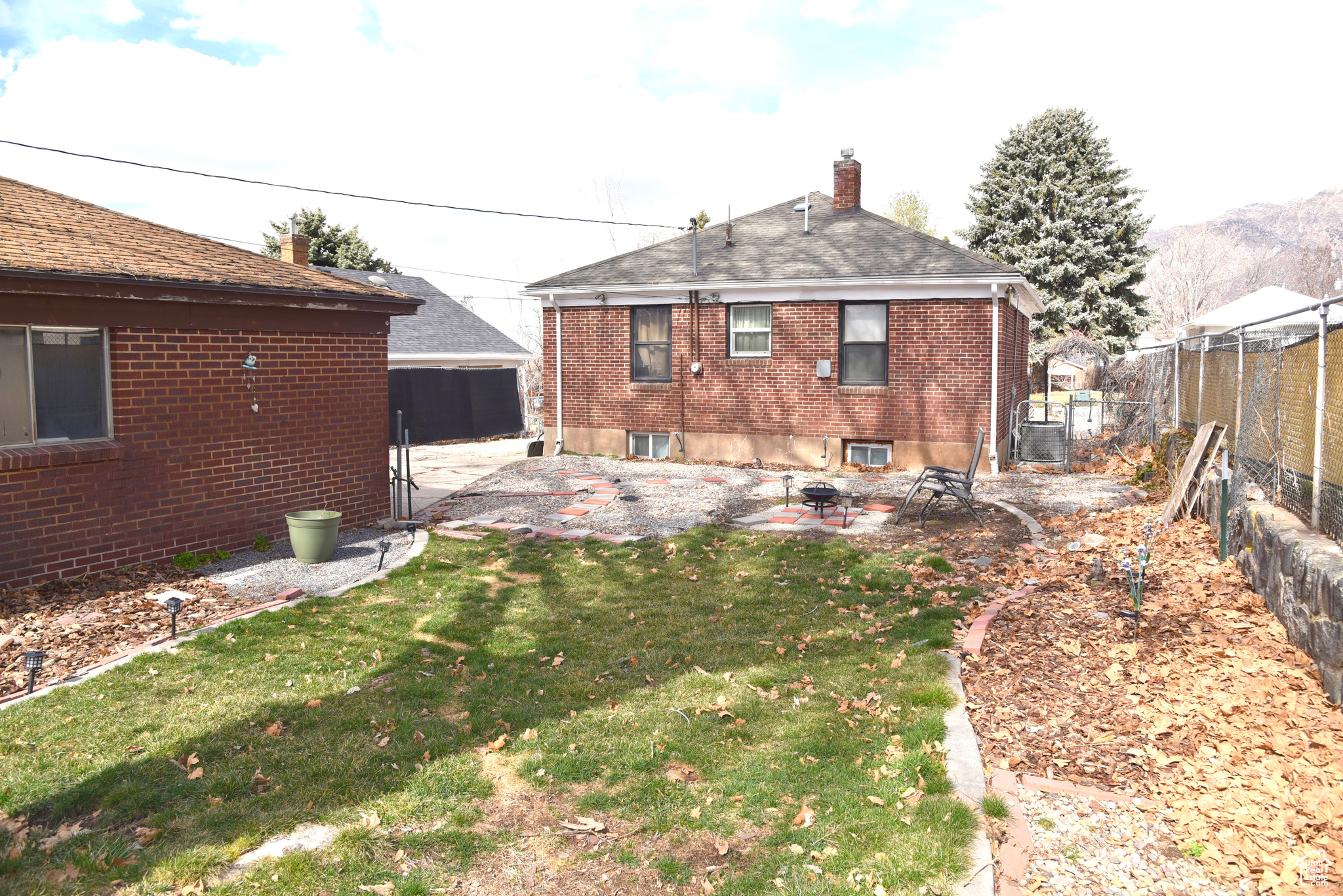 Back of property featuring grass, patio, detached 2 car garage.
