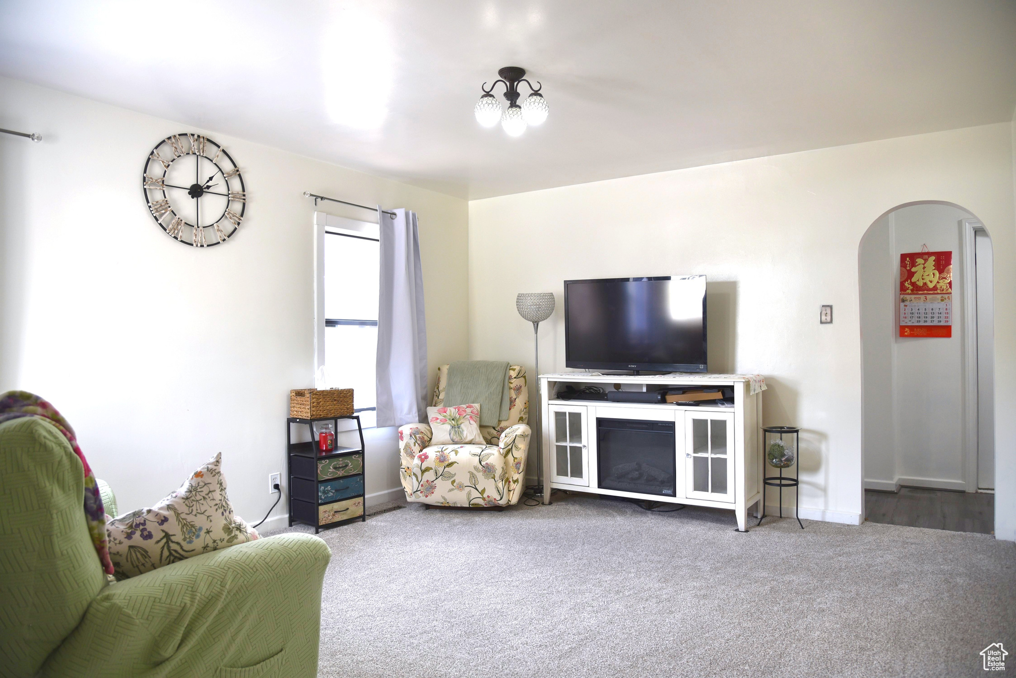 Living area featuring arched walkways and carpet flooring