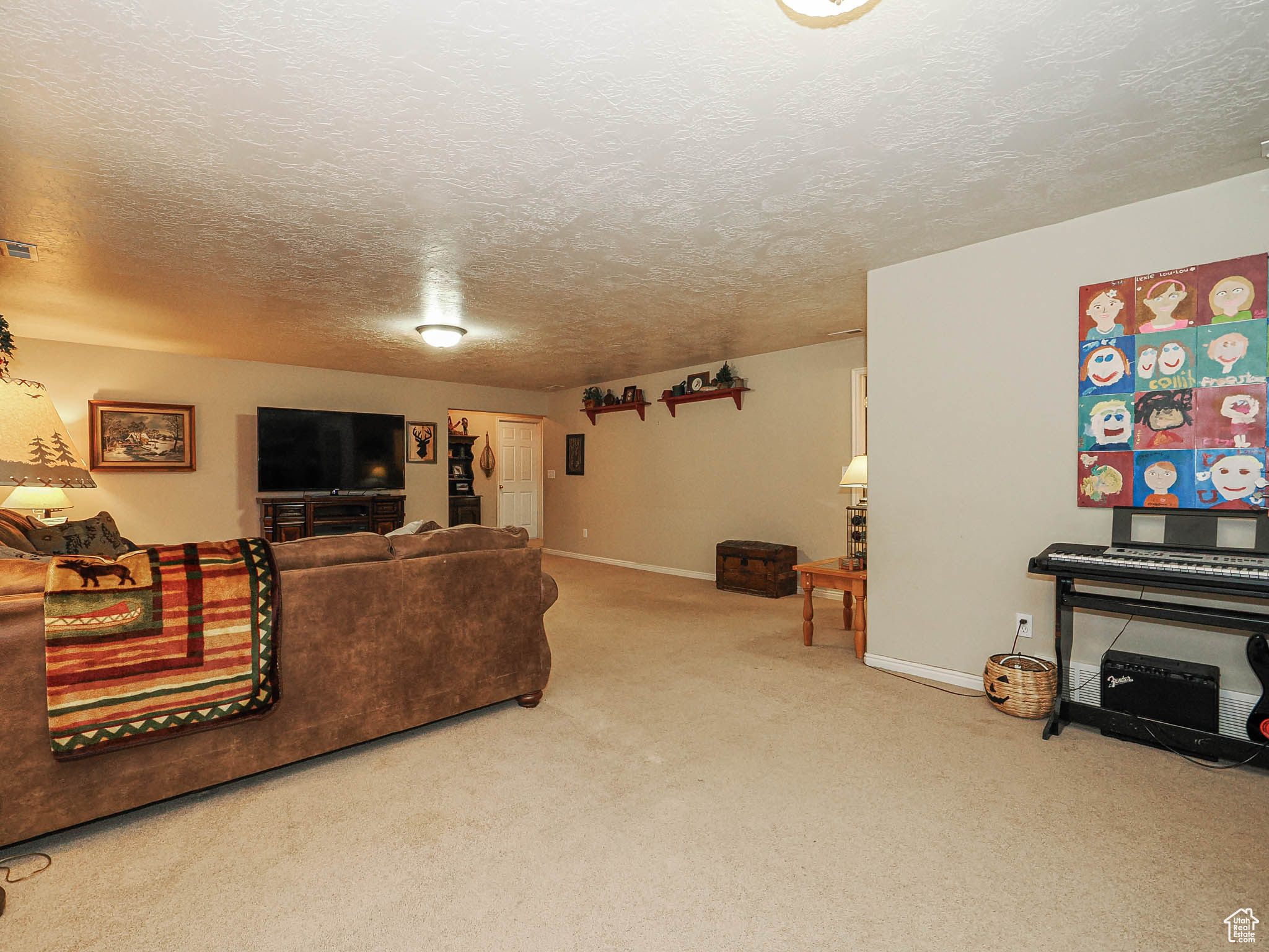 Living room featuring visible vents, baseboards, carpet, and a textured ceiling