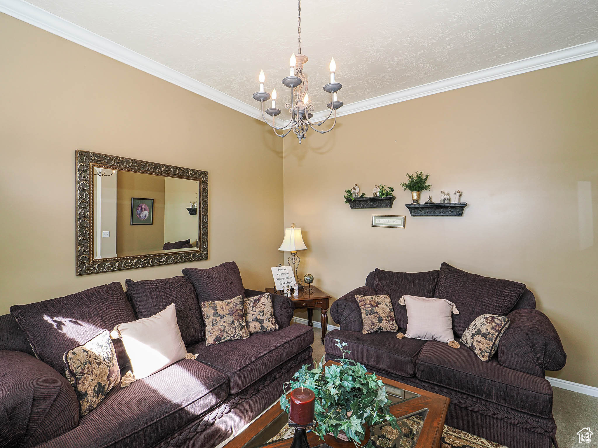 Living area with baseboards, carpet floors, an inviting chandelier, and ornamental molding