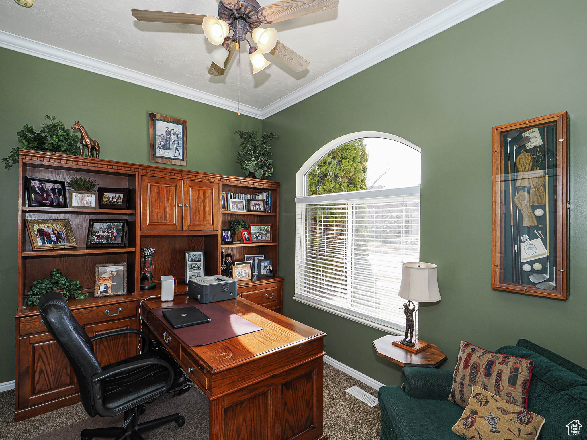 Office space featuring a ceiling fan, baseboards, carpet floors, and ornamental molding