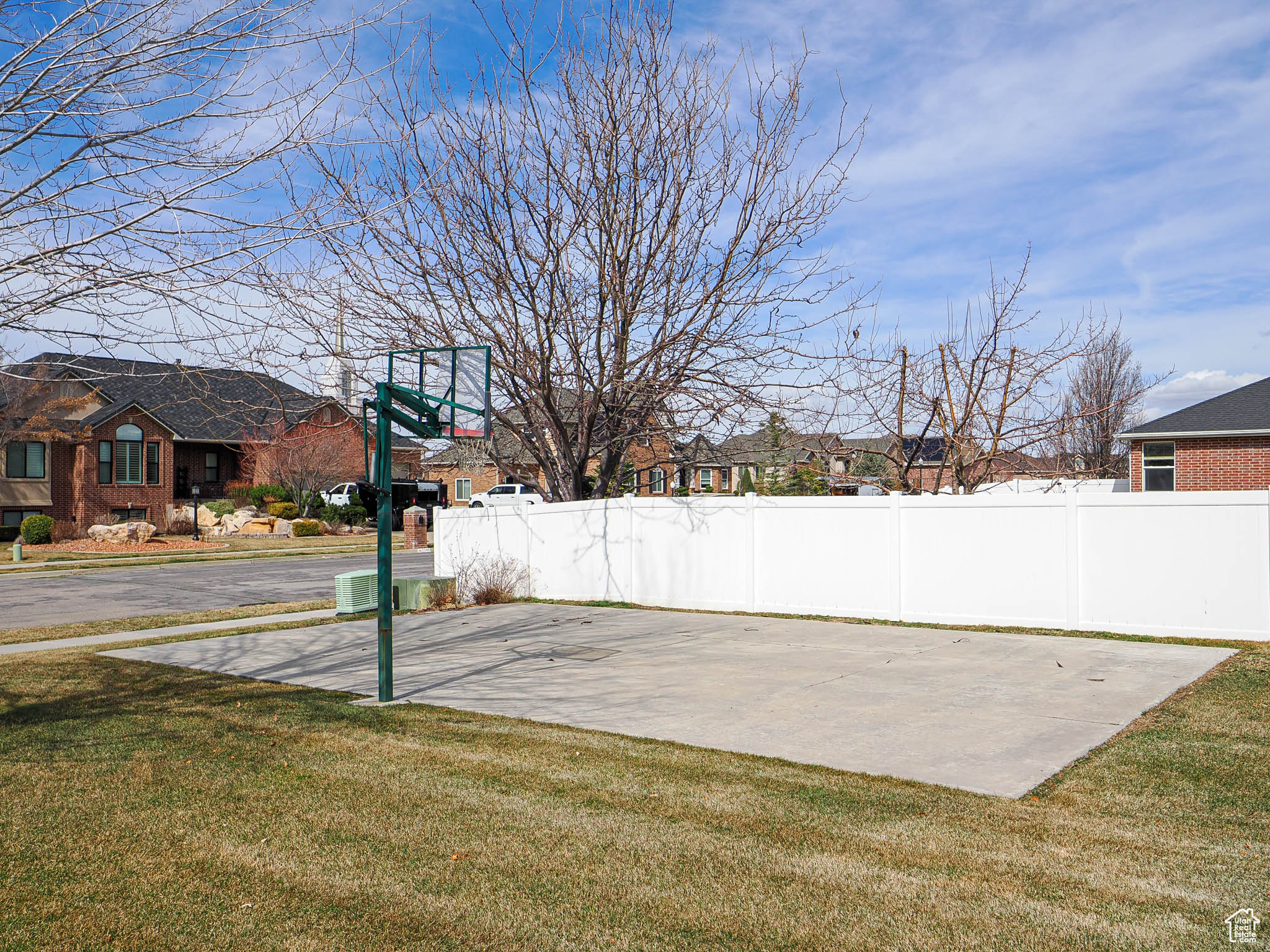 View of basketball court featuring a yard and fence