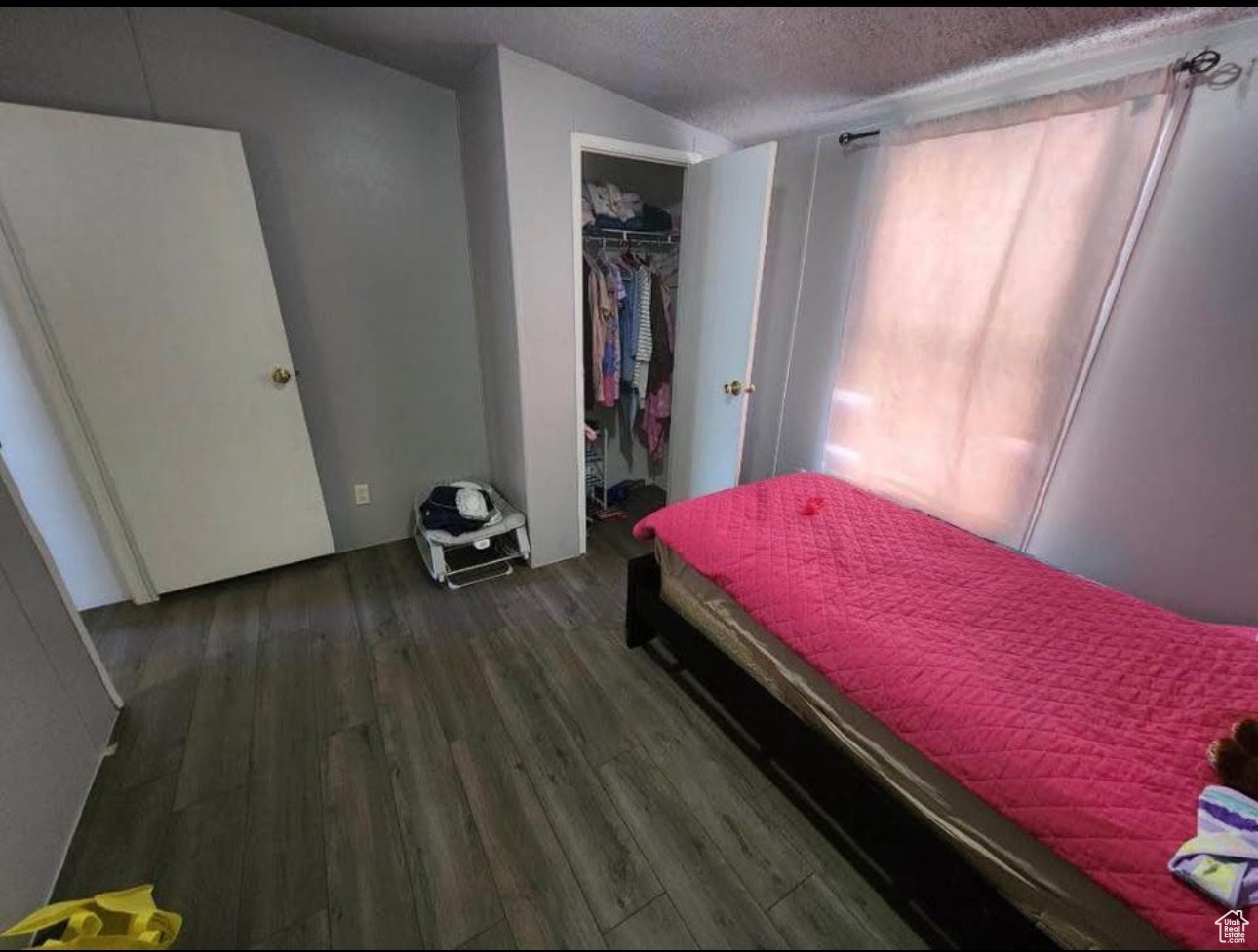 Bedroom featuring a closet, a textured ceiling, and wood finished floors