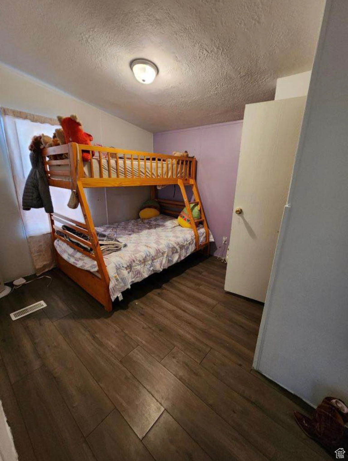 Bedroom featuring hardwood / wood-style flooring, visible vents, and a textured ceiling