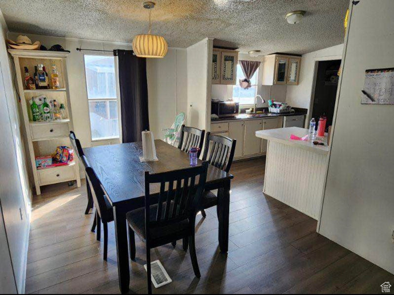 Dining room featuring visible vents, a textured ceiling, and dark wood finished floors
