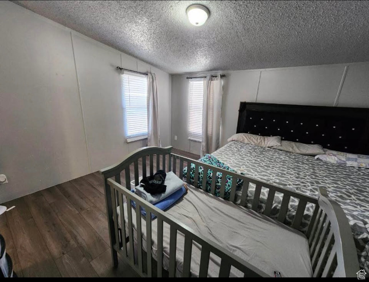 Bedroom with a textured ceiling and wood finished floors