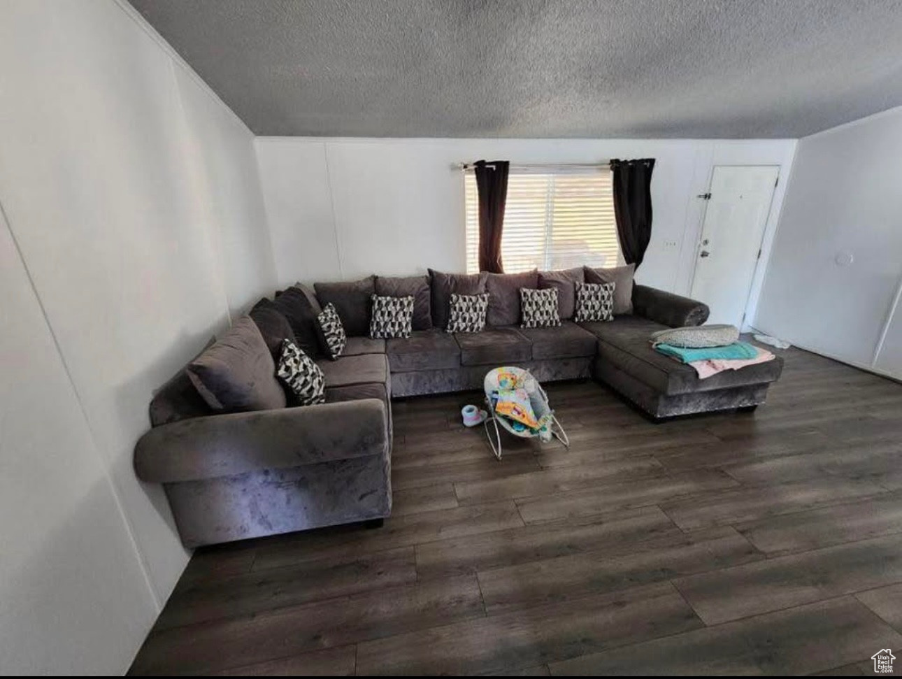 Living room with wood finished floors and a textured ceiling