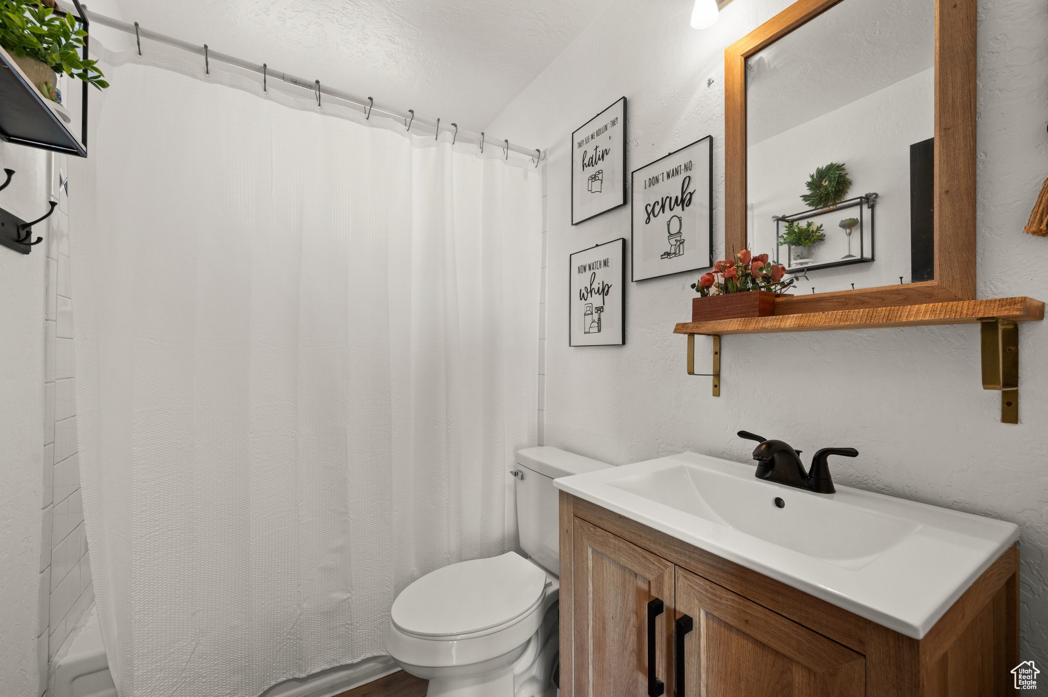 Full bath with vanity, shower / tub combo, and toilet