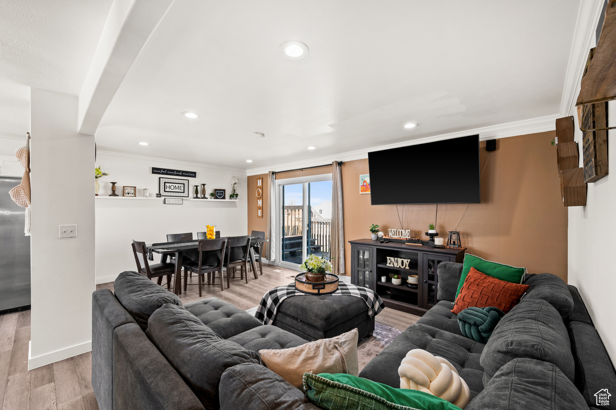 Living area with recessed lighting, wood finished floors, baseboards, and ornamental molding