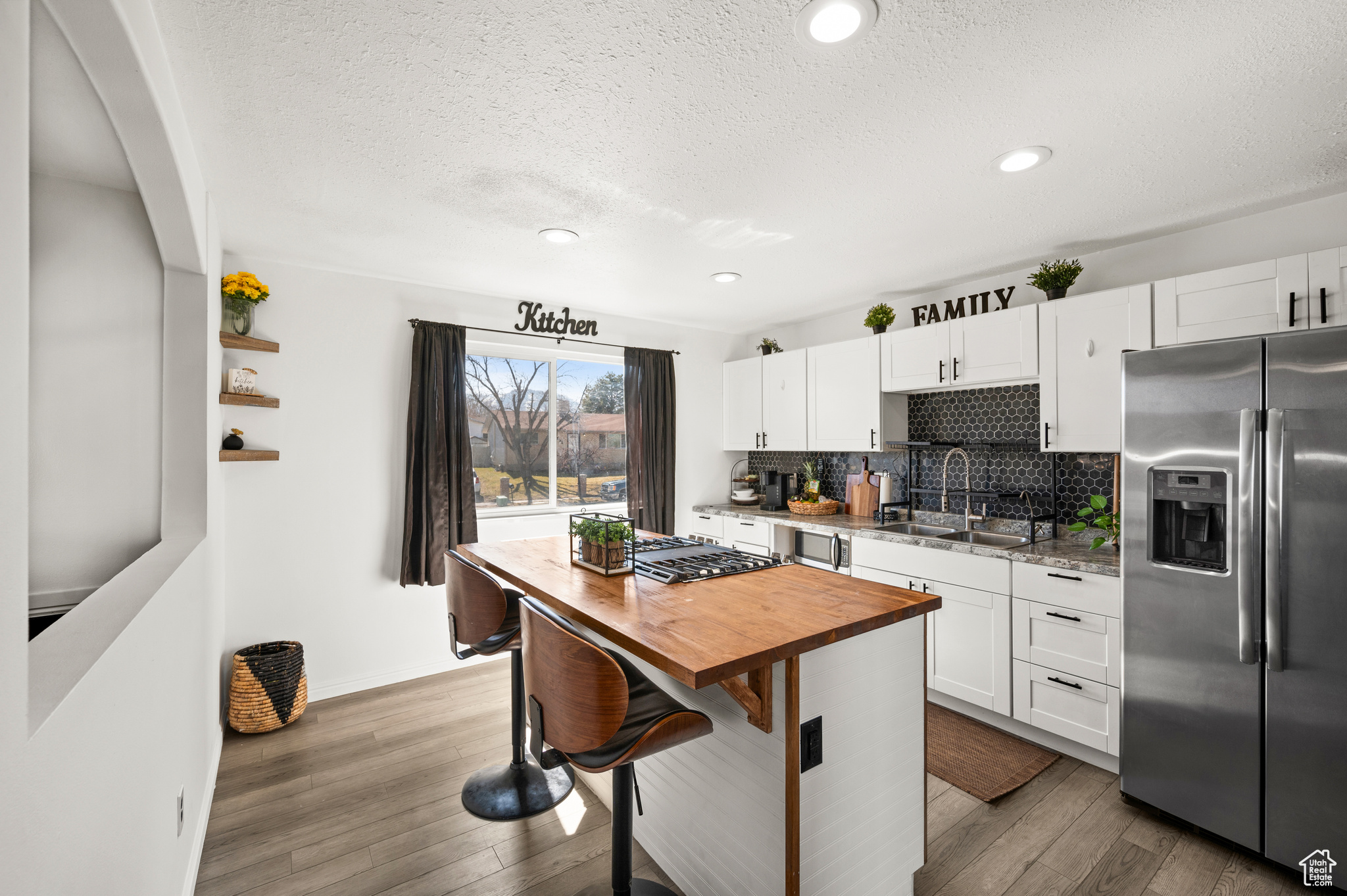 Kitchen featuring a sink, wood finished floors, tasteful backsplash, and stainless steel appliances