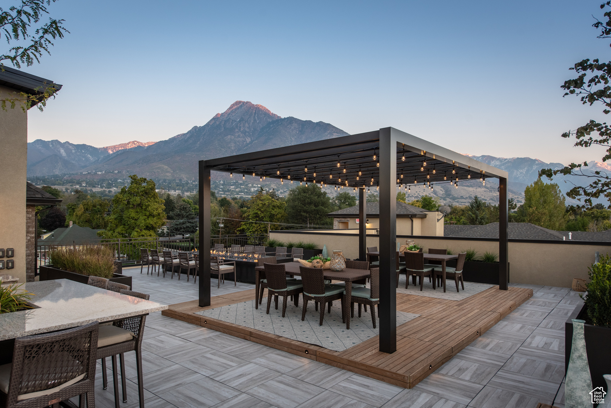 View of patio with a mountain view, outdoor dining space, and fence