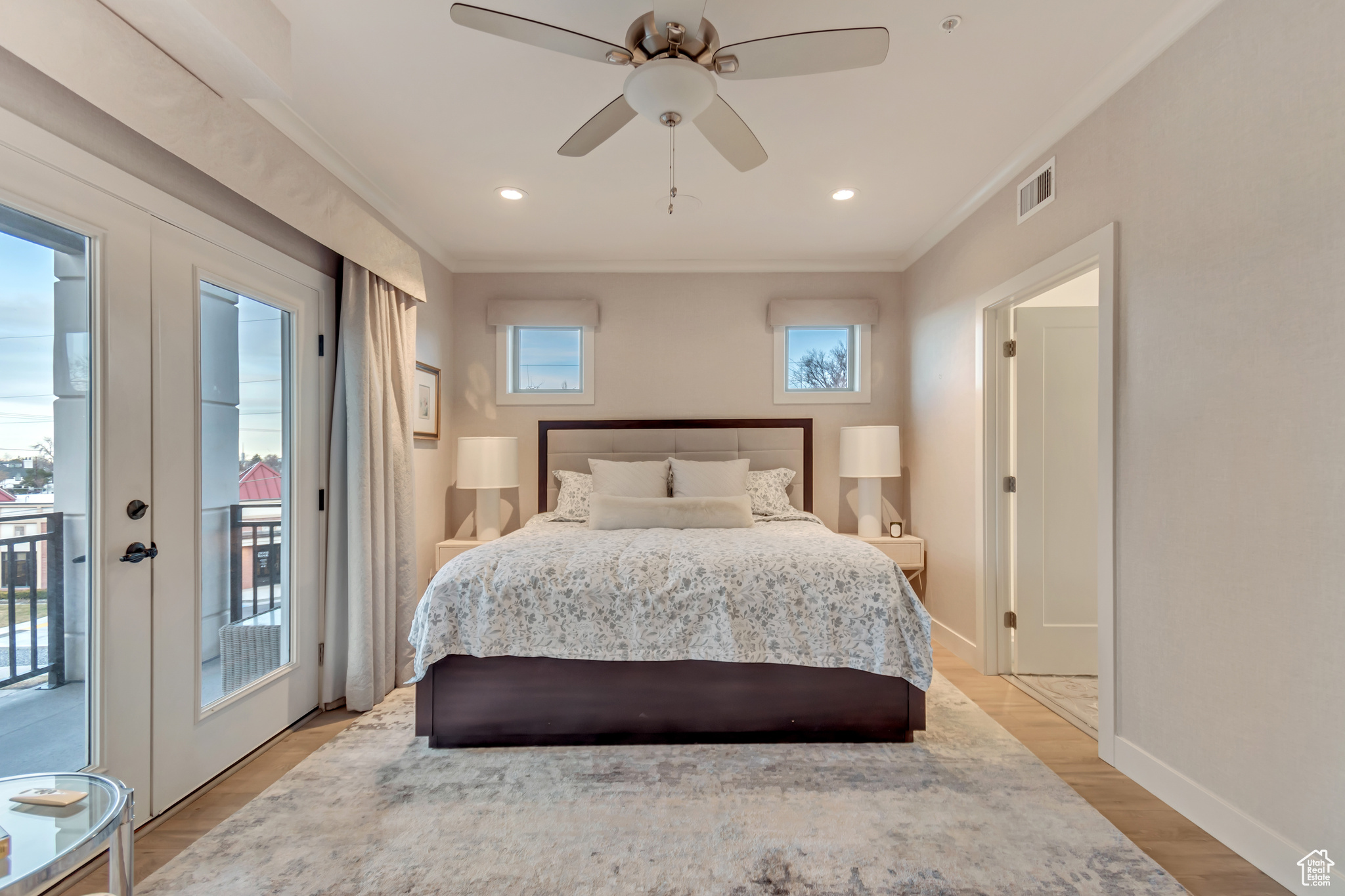 Bedroom featuring access to outside, visible vents, light wood-type flooring, and ornamental molding