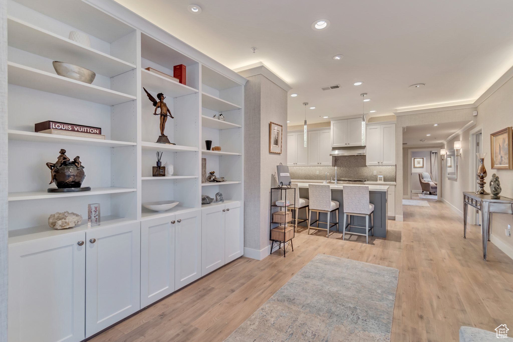 Kitchen featuring a breakfast bar, light countertops, visible vents, and light wood-type flooring