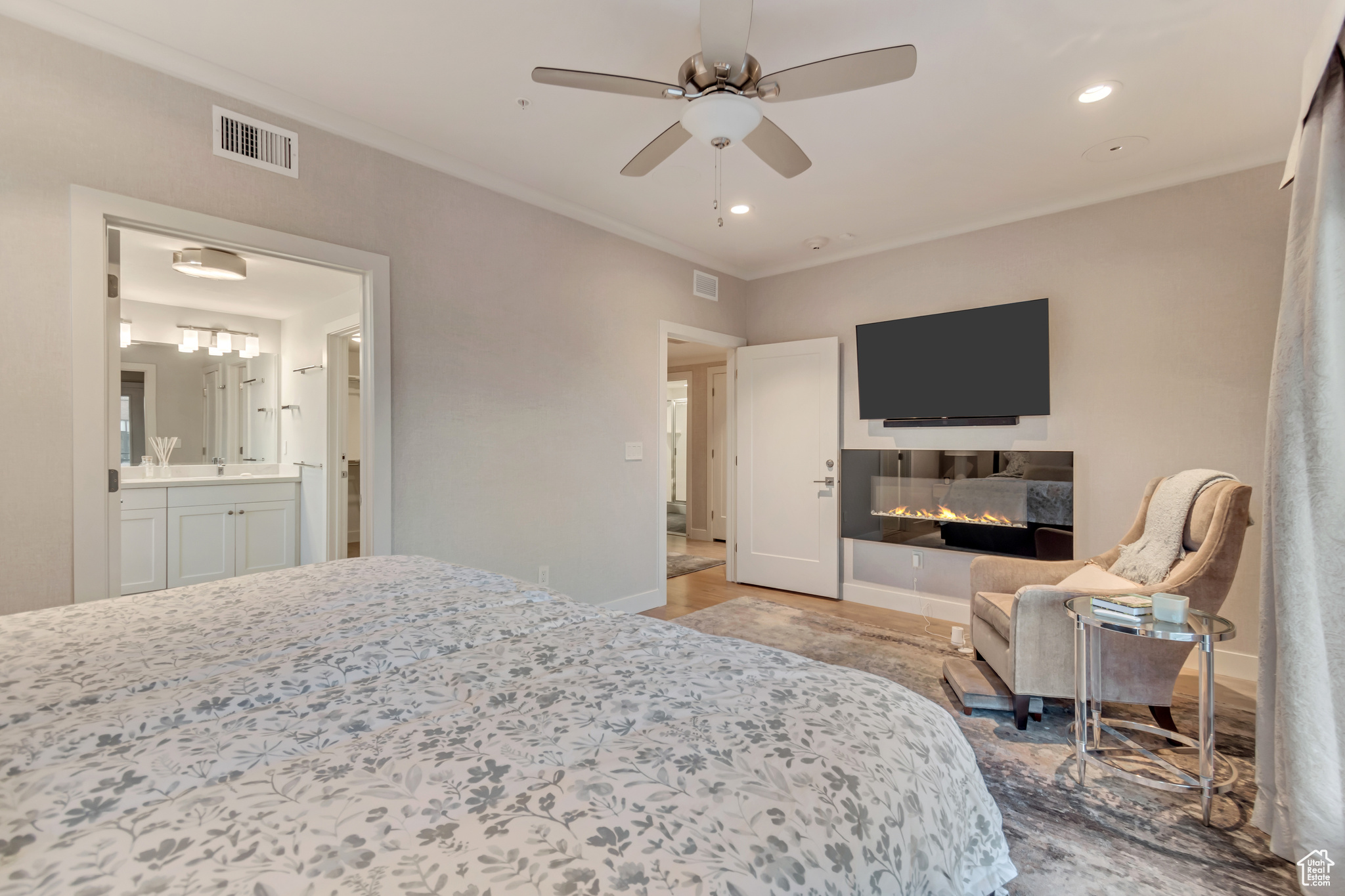 Bedroom with visible vents, ornamental molding, a glass covered fireplace, recessed lighting, and baseboards