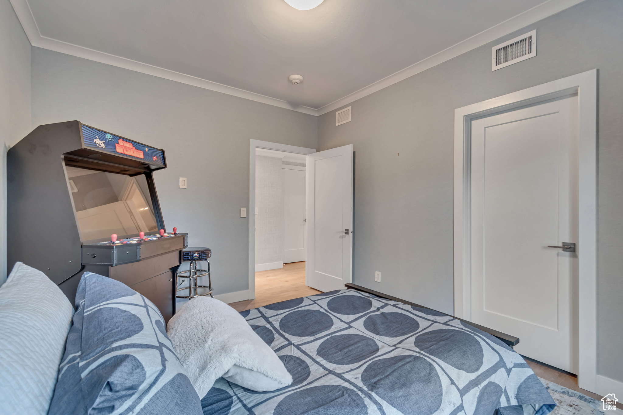 Bedroom with baseboards, visible vents, and ornamental molding