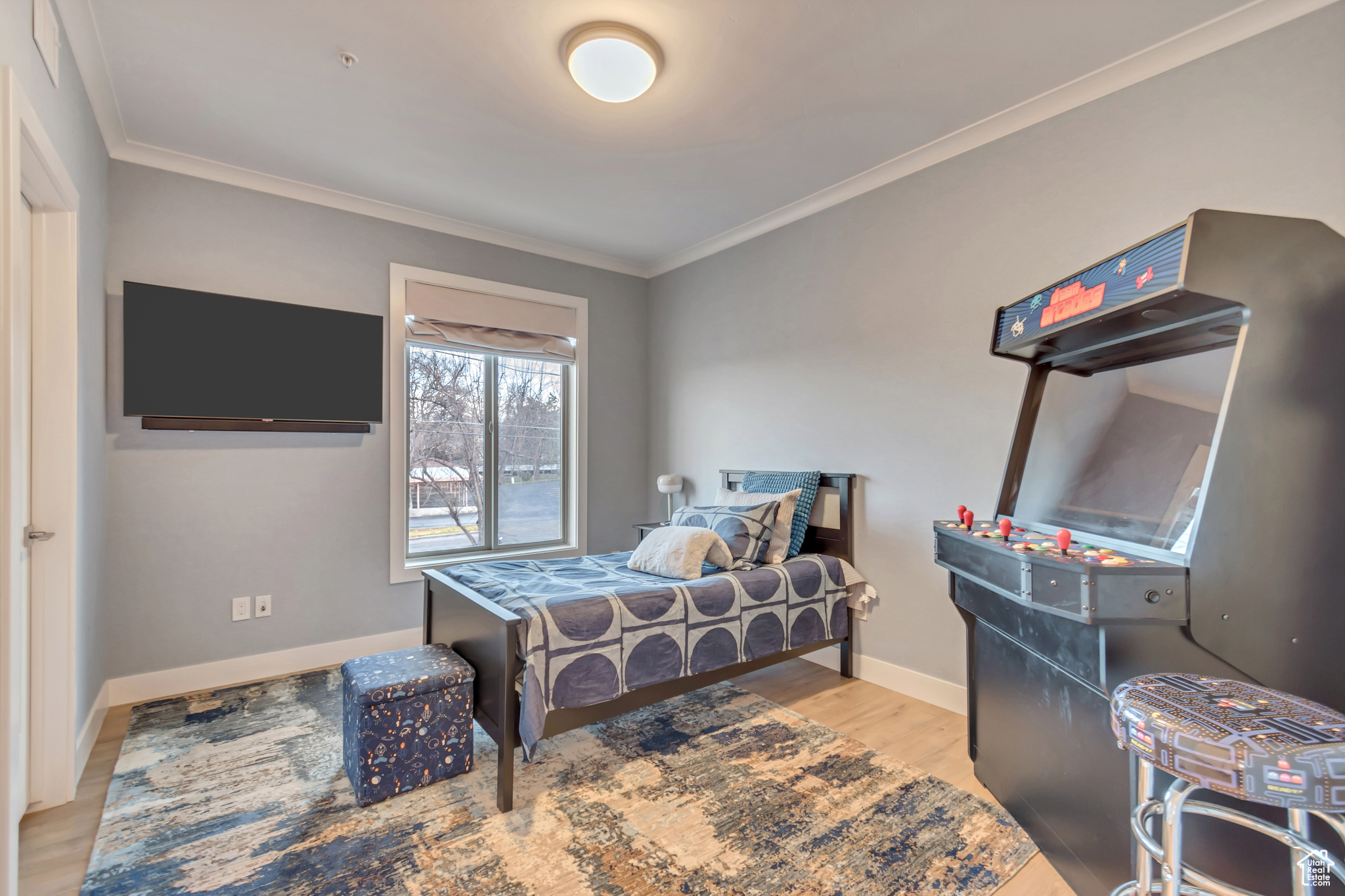 Bedroom featuring crown molding, wood finished floors, and baseboards