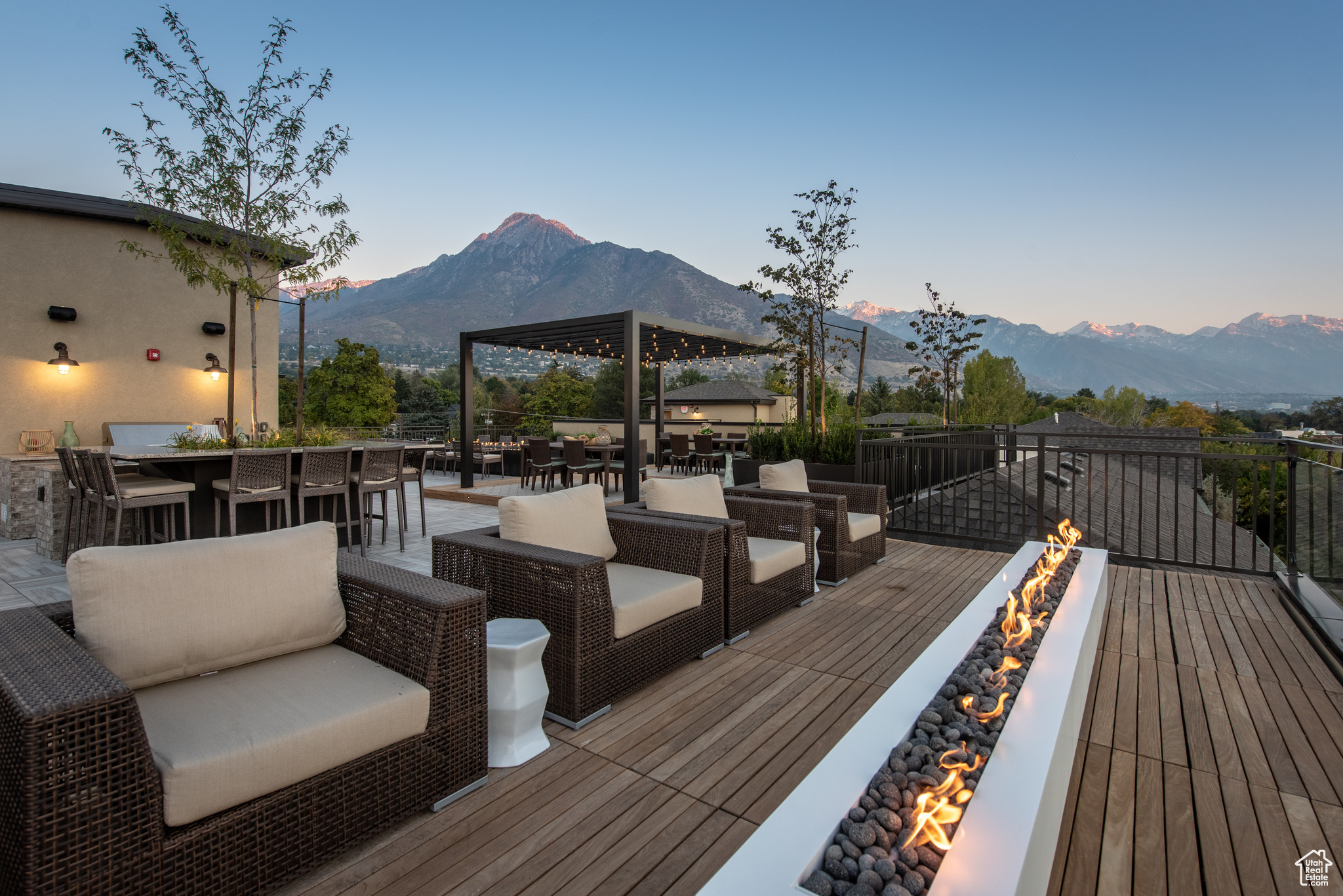 Wooden deck with outdoor dry bar, a mountain view, a fire pit, and outdoor dining area