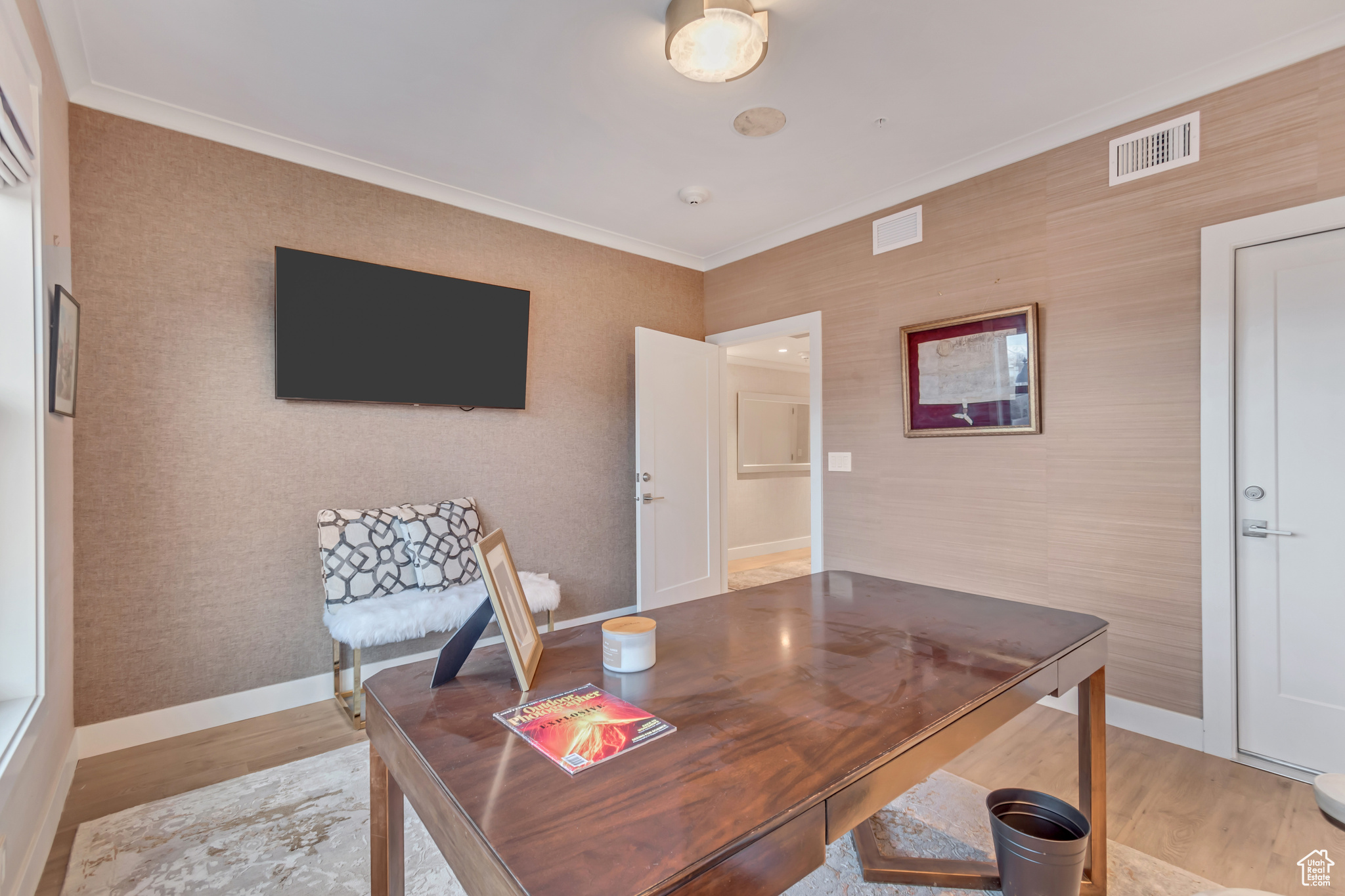 Office space featuring visible vents, ornamental molding, and wood finished floors