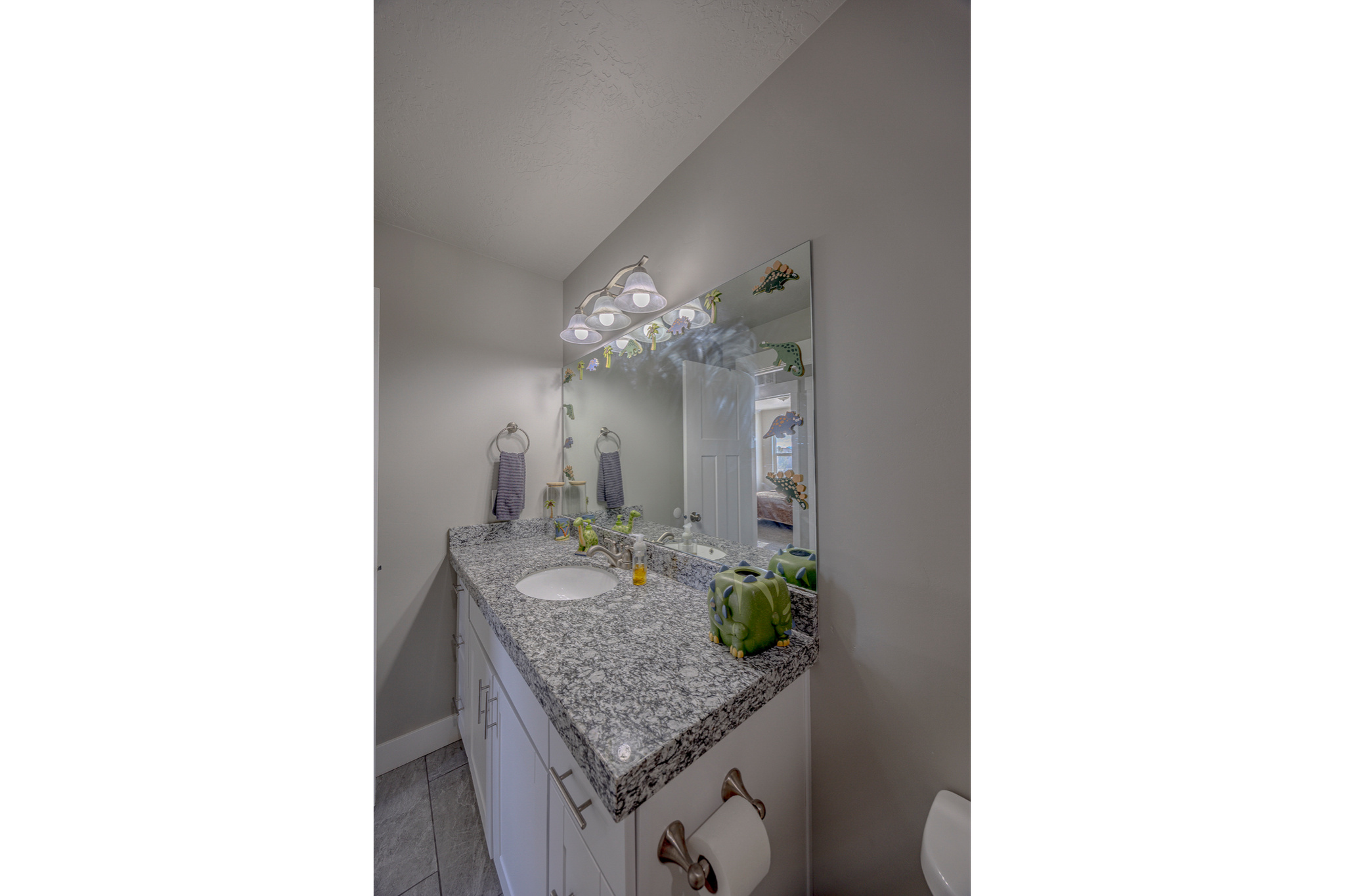 Half bath with baseboards, lofted ceiling, toilet, and vanity