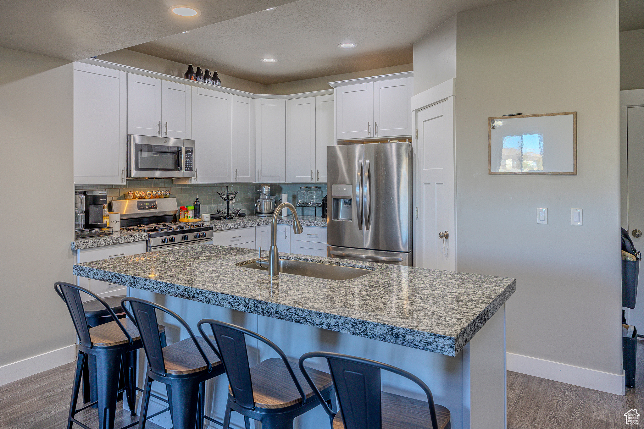 Kitchen with a breakfast bar, tasteful backsplash, appliances with stainless steel finishes, and a sink